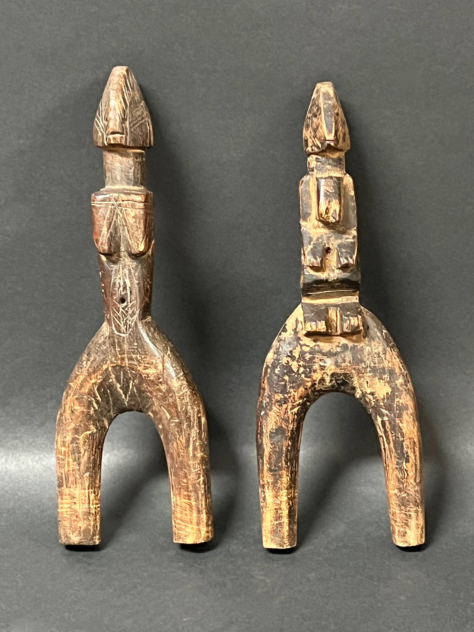 Carved Wood Pair of Slingshot: African Tribal Art Carved Wood Skull Mask. The dimension is 8 inches high x 2.5 inches wide. Please be aware that some of the items are vintage, secondhand, old ages, antiques and may have a defects