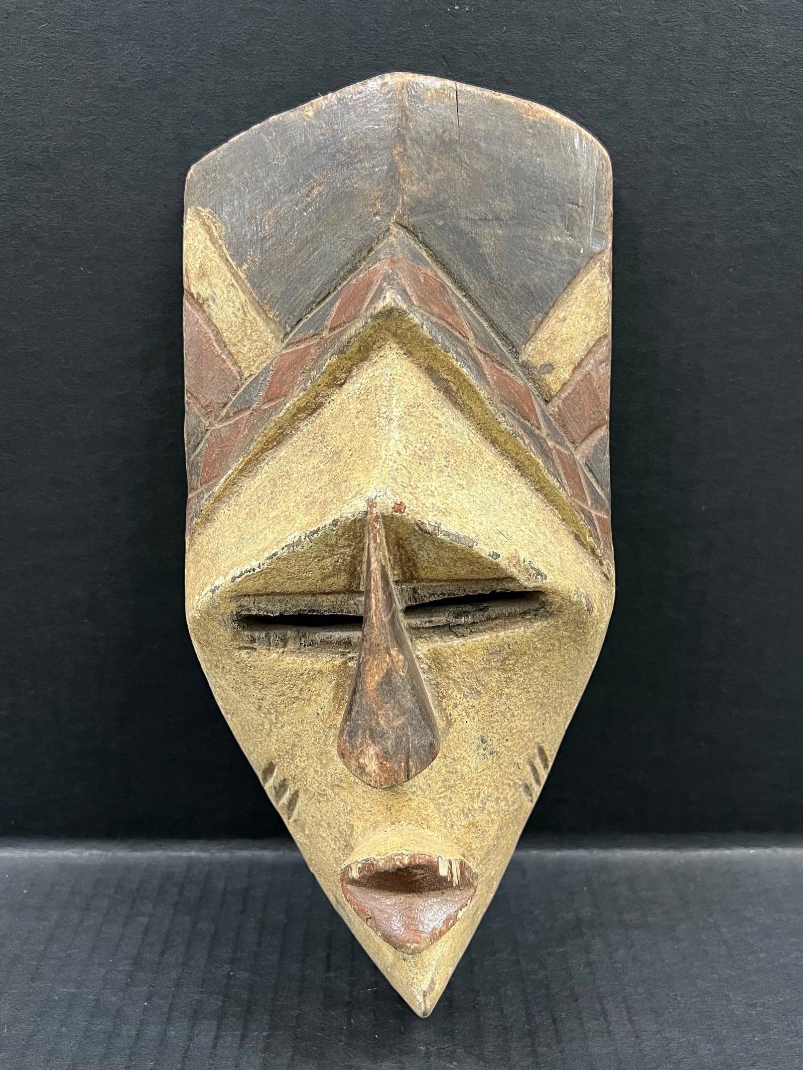 Carved Wood Tikar Mask: African Tribal Art Carved Wood Tikar Mask. The dimension is 11.5 inches high x 5.5 inches wide. Please be aware that some of the items are vintage, secondhand, old ages, antiques and may have a defect