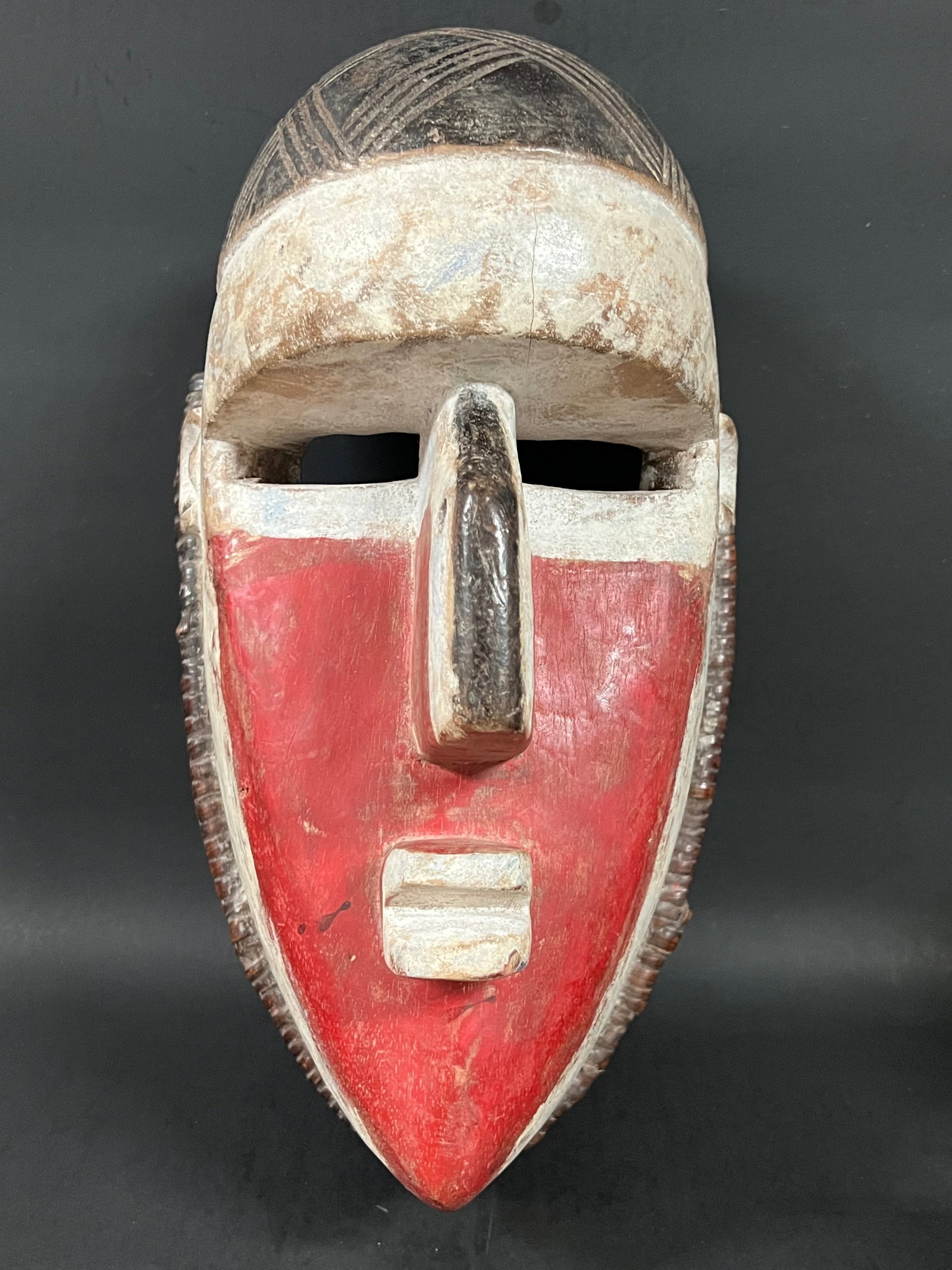 Carved Wood Lwalwa Mask: African Tribal Art Lwalwa Mask. The dimension is 14.5 inches high x 8 inches wide. Please be aware that some of the items are vintage, secondhand, old ages, antiques and may have a defects or sign of 