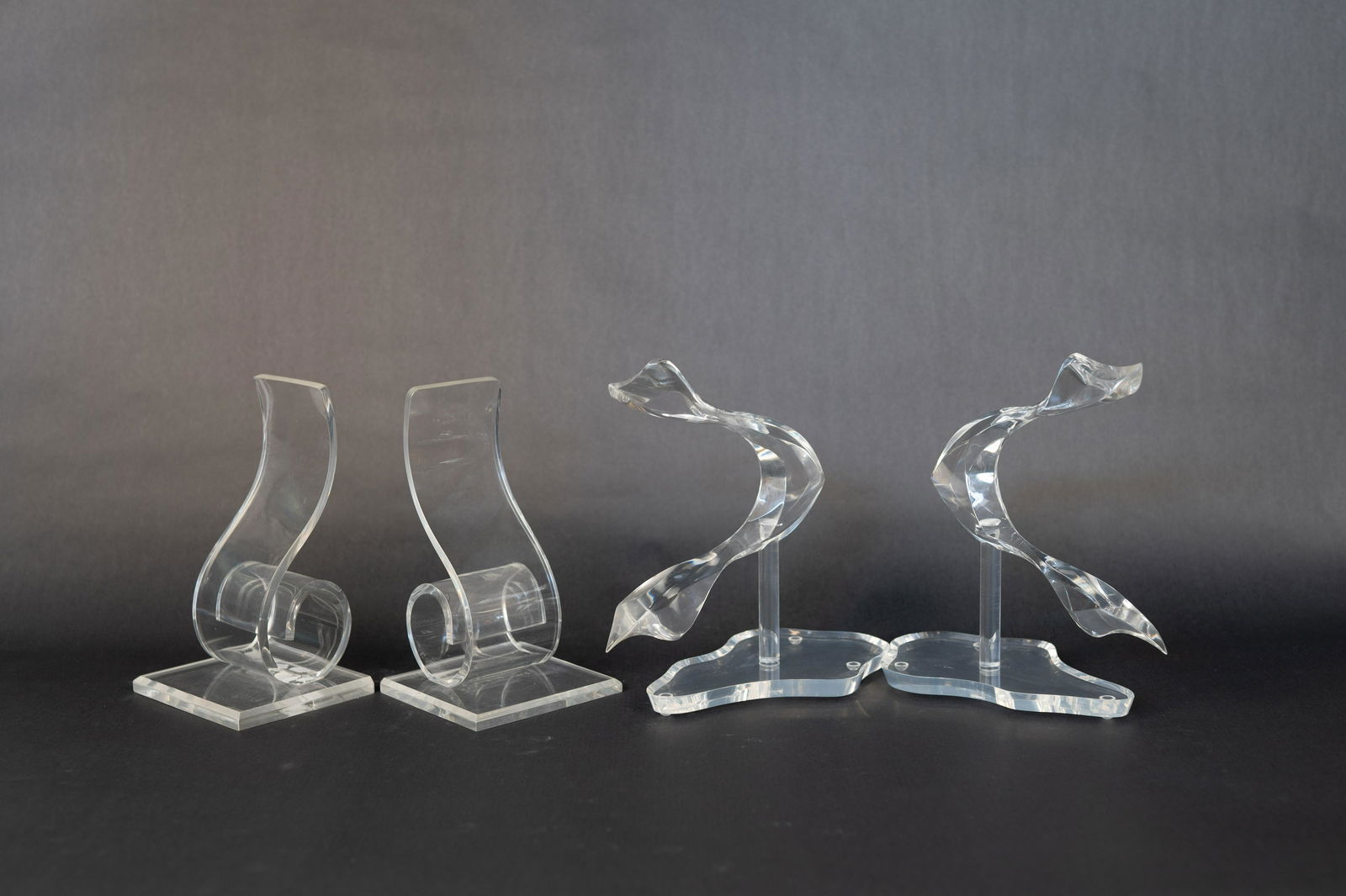 2 Sets of Lucite Bookends/Sculptures: One set featuring a spiral design and the other an abstract shape.