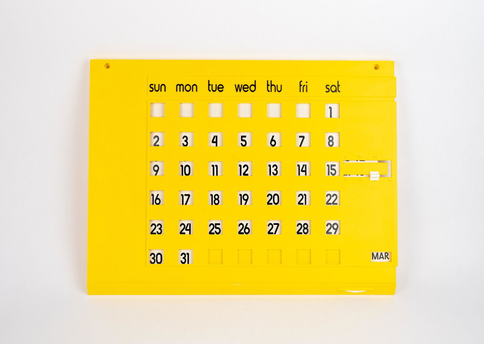 Yellow Plastic Perpetual Wall Calendar: Allows for adjusting the month and the first day of each each month so the dates line up with the correct day of the week. 17.15 inches wide, 13.25 inches tall and .75 inches deep. Unmarked.