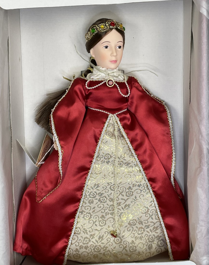 Effanbee: The New World Collection Queen Isabella: 14" hard plastic Queen Isabella Doll Limited Edition #1491. Beautiful long brown hair. She is wearing a full-length maroon-colored gown w/ gold and white trim and a gold and white front panel. Matchin