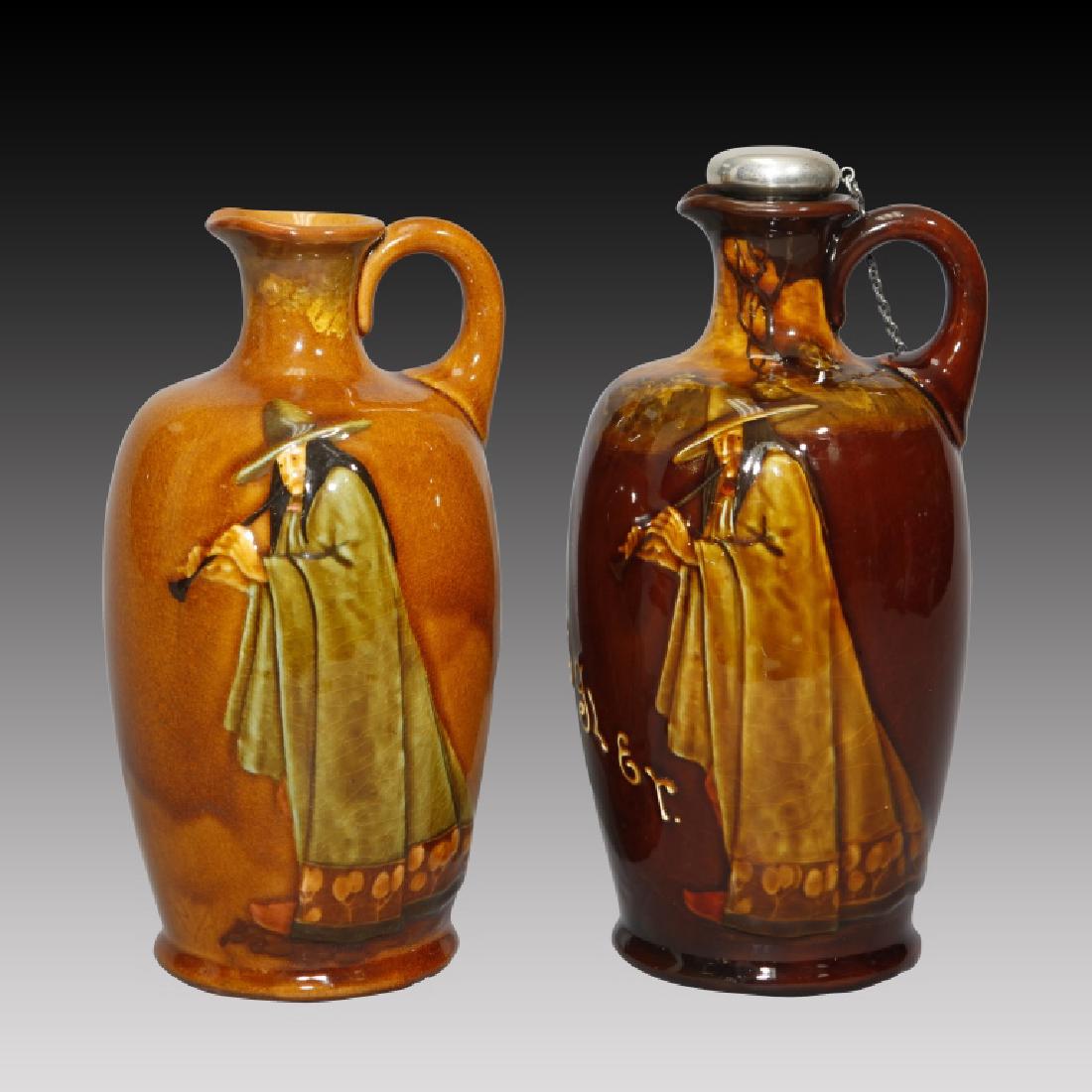 Two Doulton Kingsware Whiskey Flasks Pied Piper: Royal Doulton Pair of Pied Piper Kingsware Whiskey Flasks. 1] Darker glaze with Sterling stopper and chain. Not attached to handle. 9.0"H. 2] Lighter glaze flask 8.5"H.; Issued 20th century. Origin: E