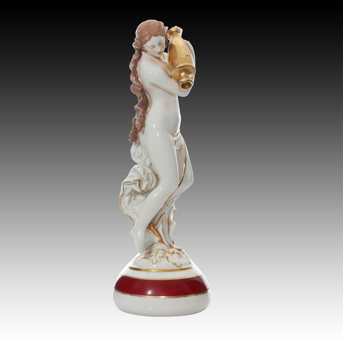 Royal Dux Maiden Pouring water Container Figurine: Royal Dux Maiden Pouring water Container Figurine Royl Dux figurine of a maiden carting a water container. She has long brown hair and the water vessel is painted gold. Origin: Bohemia Size: 14.0" H I