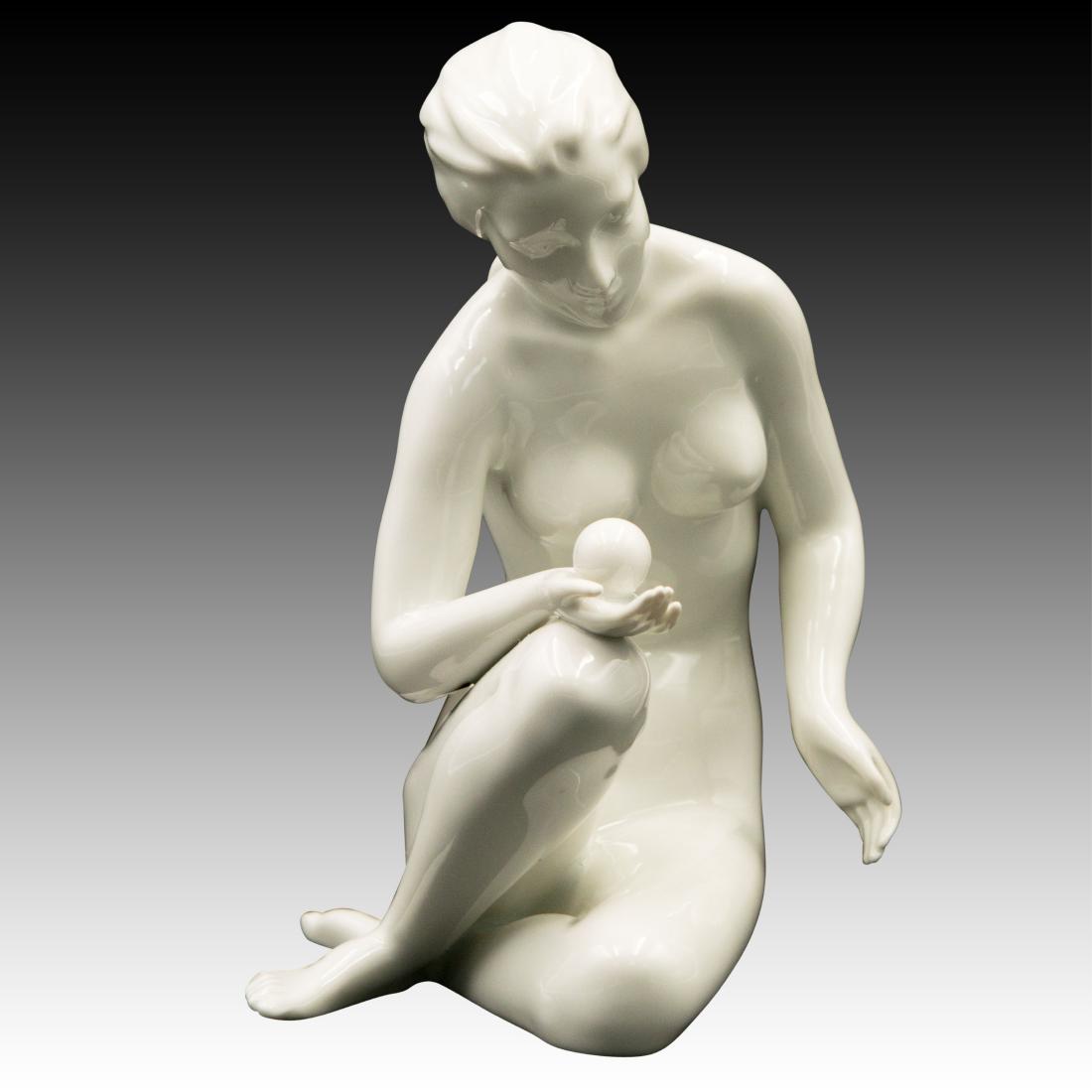 Royal Dux Nude Woman with a Ball Figurine: Royal Dux Nude Woman with a Ball Figurine Royal Dux figurine of a nude young woman with a ball in her hand sitting on the floor. Origin: Bohemia Size: 7.5" H Issued: 20th century