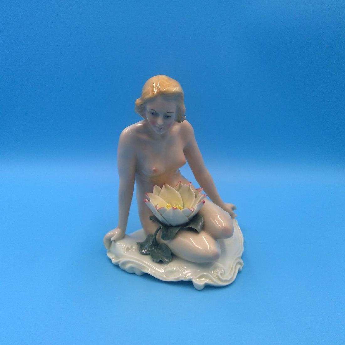 KARL ENS GERMAN PORCELAIN FIGURINE NUDE w FLOWER: Karl Ens Germany Art Deco Porcelain Figurine of a Nude Nyprh Sitting with Water Lily Flower. Circa 1920s. ; Dimensions: 6.5"H x 5.5"L x 5"W;