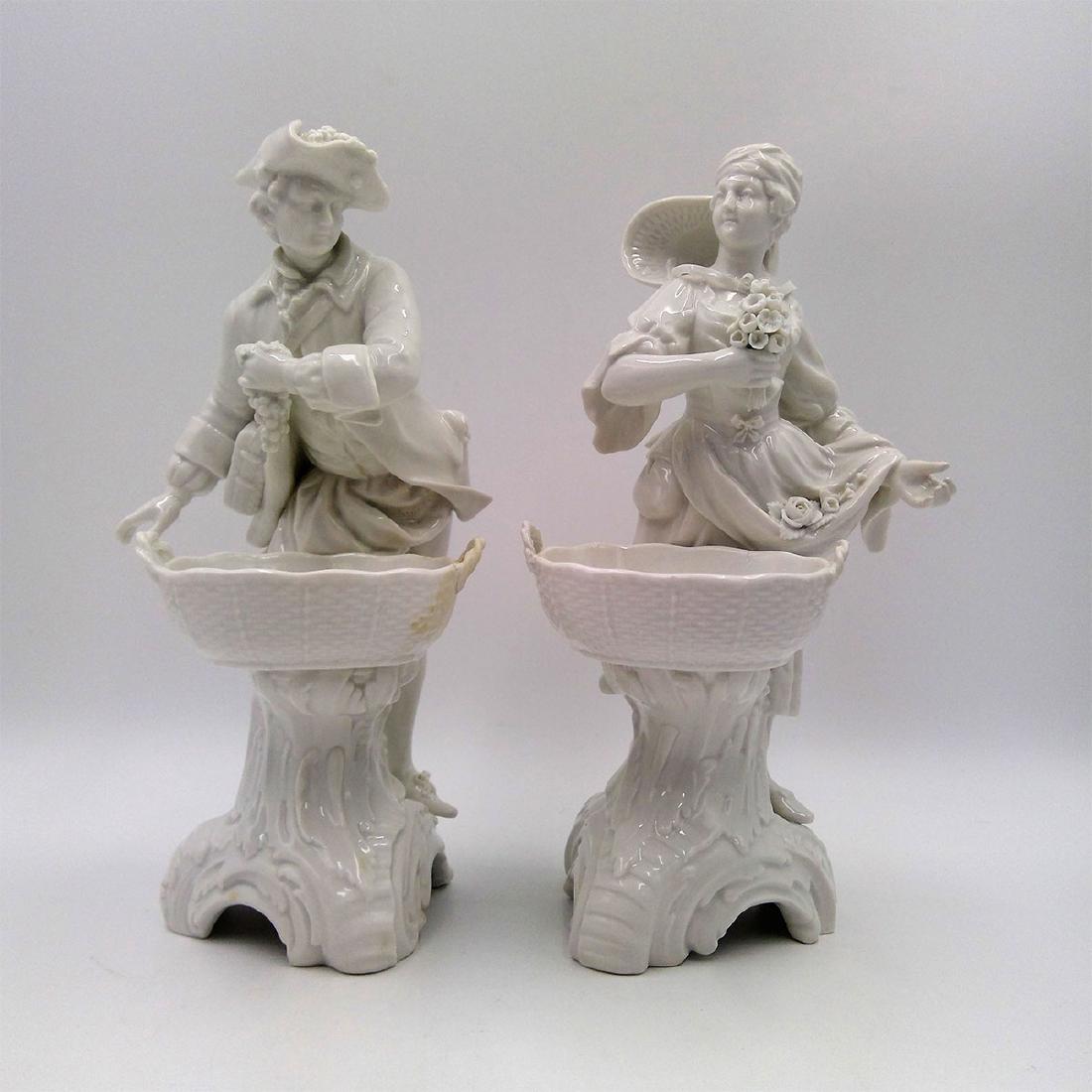 PAIR OF KPM BERLIN PORCELAIN FIGURES WITH BASKETS: Group of 2 KPM Blanc de Chine Figurines with Baskets of a Lady with Flowers and a man with Grapes. Circa late 19th / early 20th century.