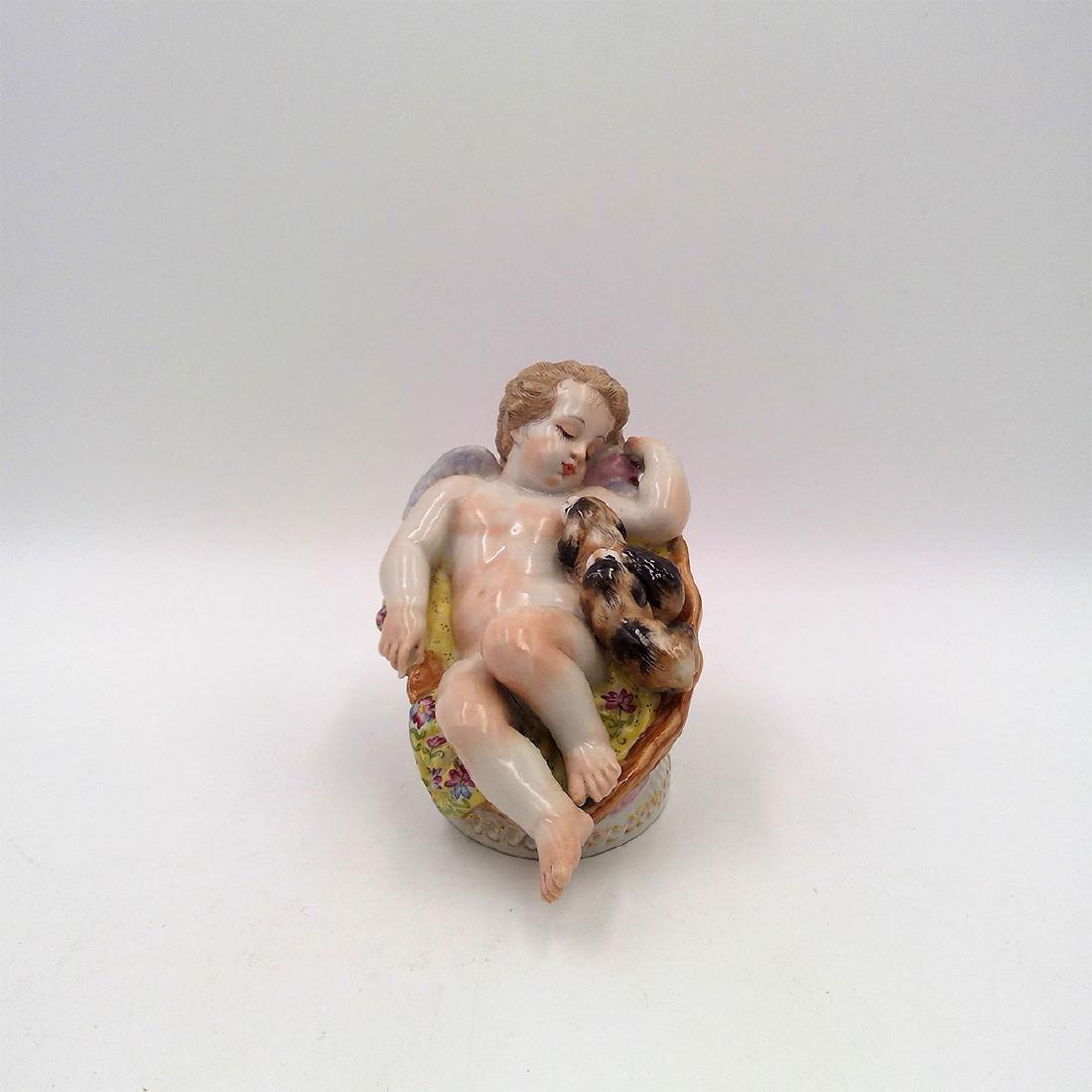 MEISSEN 19thC PORCELAIN FIGURINE CHERUB w DOGS: Meissen Figurine of an Angel Laying on a Coach with Two Puppies. Inscribed numbers 17.13. painted number 21. Circa 19th century. Country of Origin: Germany; Dimensions: 5"L x 4"H x 3.25"W;