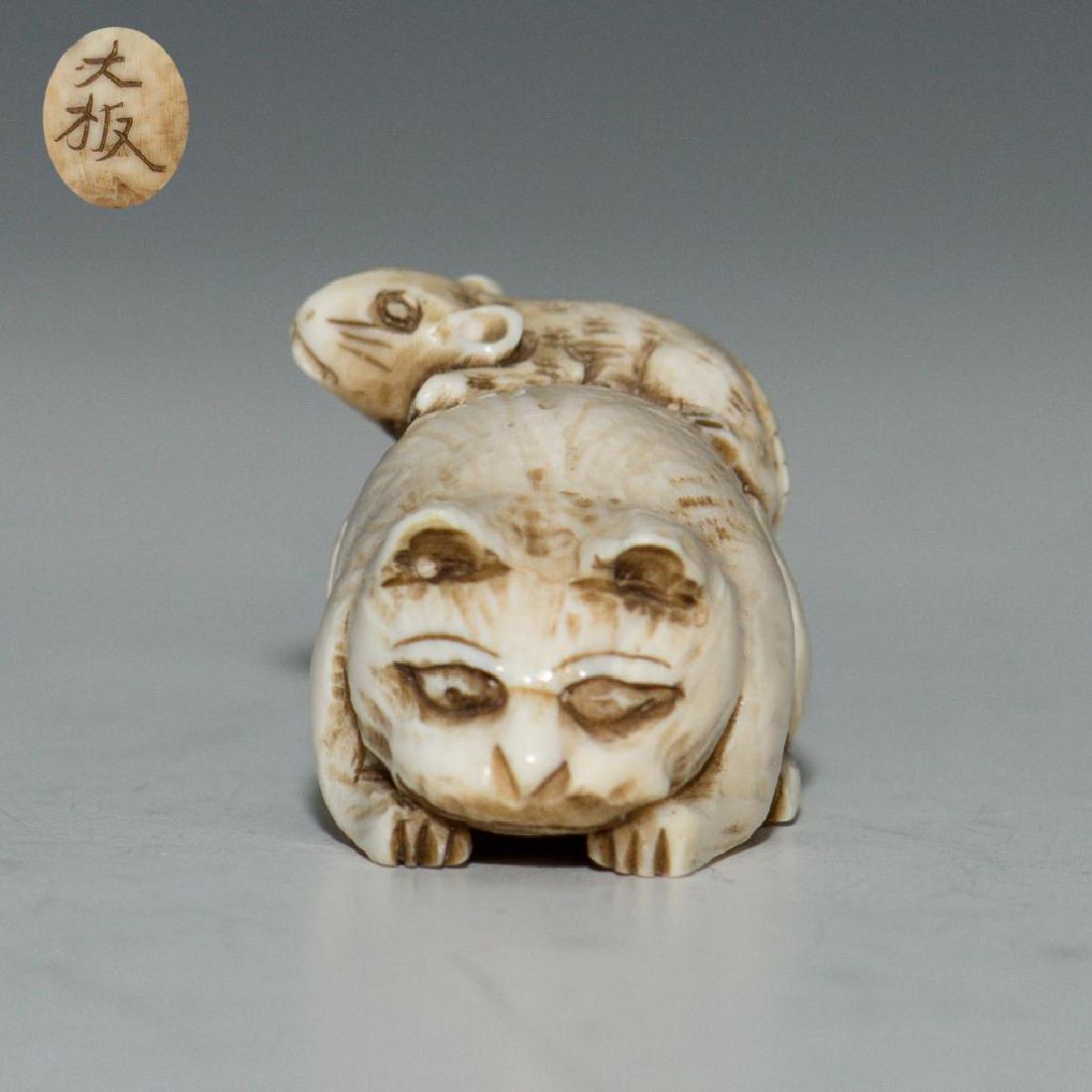 ANTIQUE CARVED BONE JAPANESE NETSUKE FIGURE CAT & MOUSE: Netsuke carving depicting a mouse sitting on a cat. Marked on the bottom. Dimensions: 1.5"L x 1"H Country of Origin: Japan