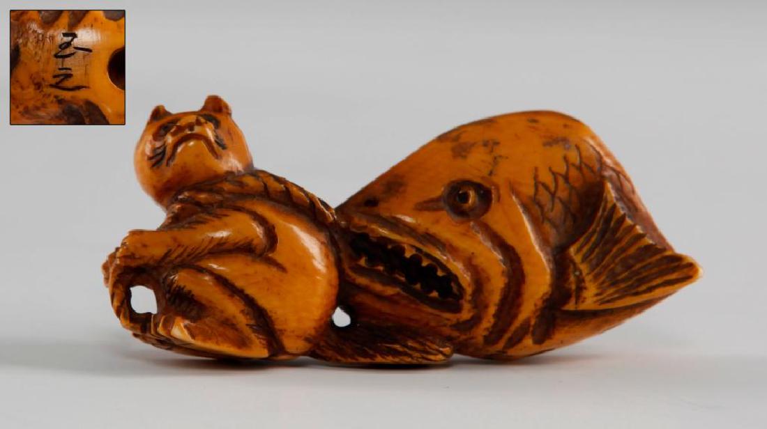 ANTIQUE JAPANESE CARVED BONE NETSUKE GROUP FIGURE: Netsuke carving of a racoon and a fish. Signed on the bottom. Dimensions: 2.5"L Country of Origin: Japan