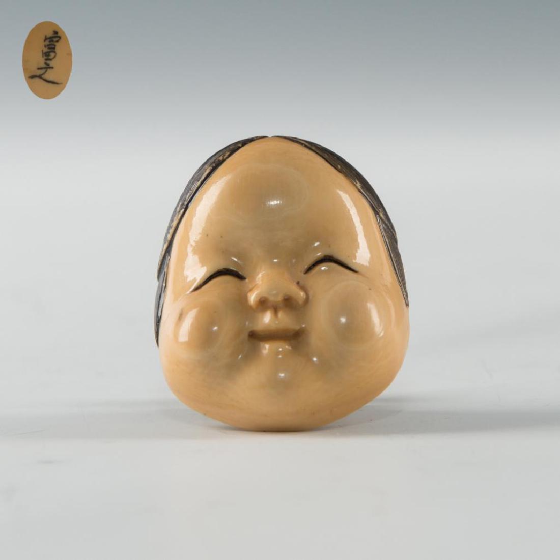 ANTIQUE JAPANESE CARVED BONE NOH FACE MASK NETSUKE: Netsuke carving of a Noh Mask. Signed on the back. Dimensions: 1.75"L Country of Origin: Japan