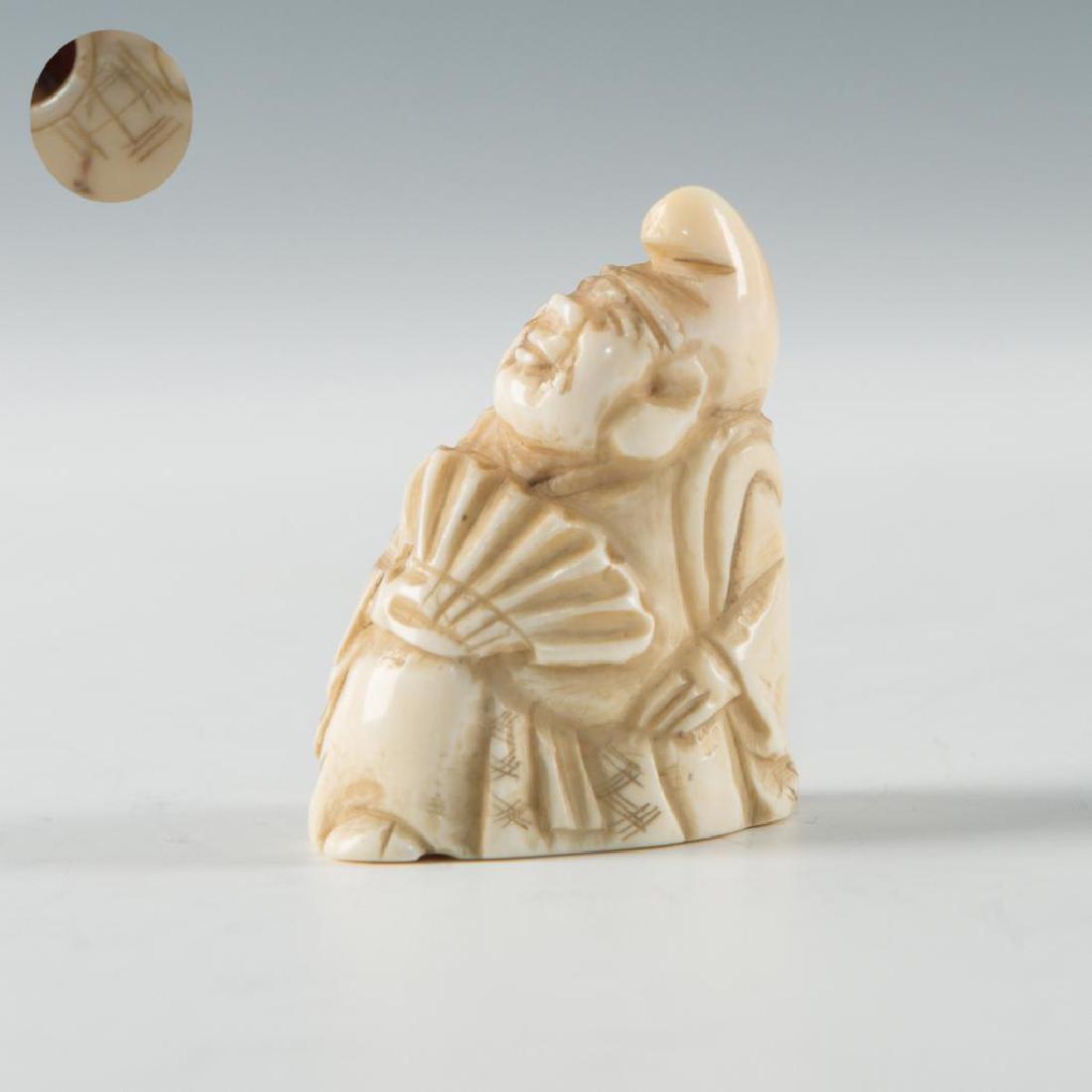 ANTIQUE JAPANESE CARVED BONE NETSUKE MEN WITH FAN: Netsuke carving of a man holding a fan and looking up. Inscribe mark on the base. Dimensions: about 1.5"L Country of Origin: Japan