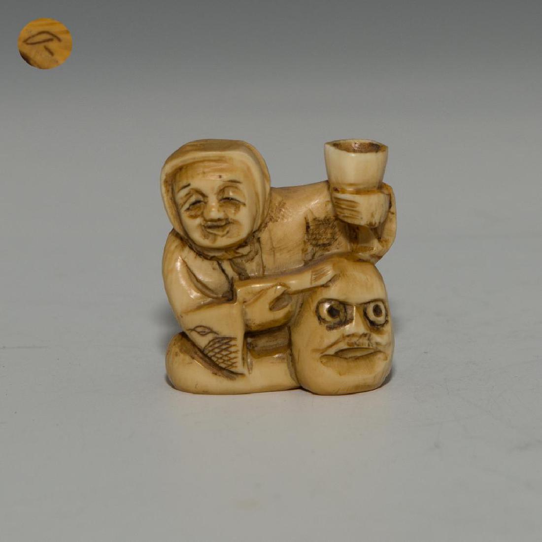 ANTIQUE JAPANESE CARVED BONE NETSUKE MASK MAKER: Netsuke carving figure of a man making a mask. Inscribed signature on the bottom. Dimensions: 1.5"H Country of Origin: Japan
