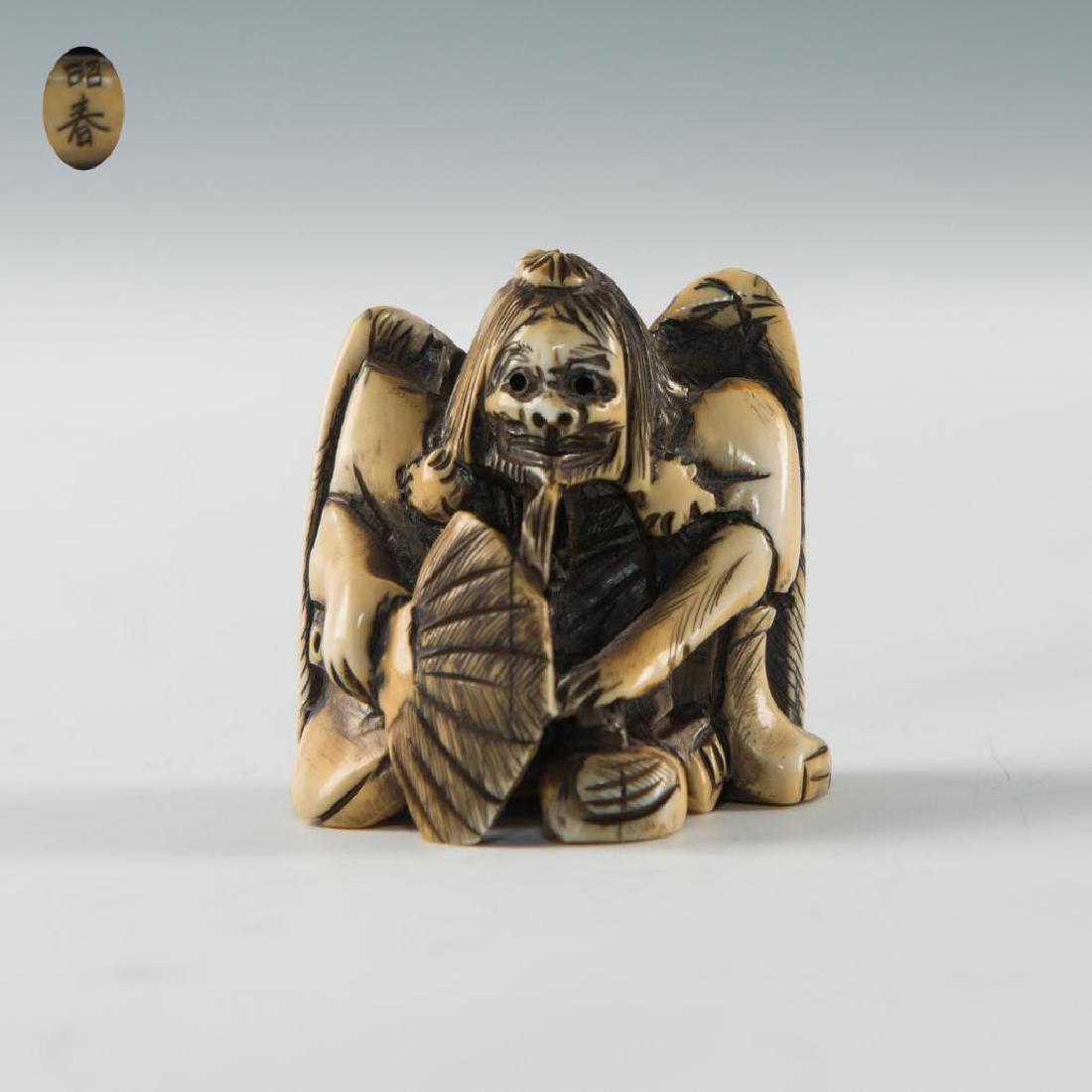 ANTIQUE JAPANESE CARVED BONE NETSUKE MAN WITH WINGS: Netsuke carving figure of a man with wings holding a fan. Inscribed signature on the bottom. Dimensions: 1.5"H Country of Origin: Japan