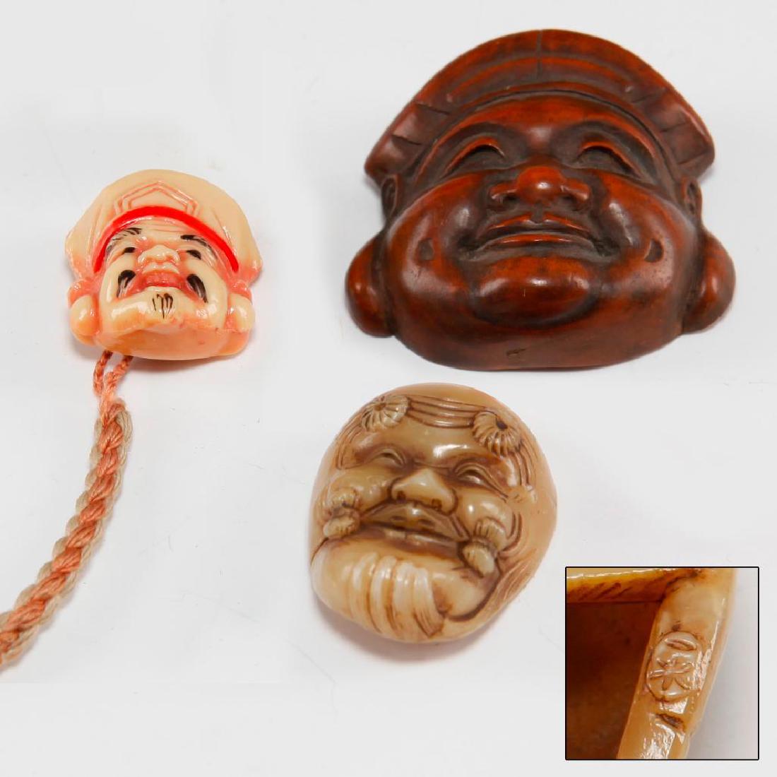SET 3pc ANTIQUE JAPANESE CARVED BONE & WOOD NETSUKE: Group of 3 Mask netsuke carvings. 1) Jade color plastic miniature mask (1.25"H). Circa 1920s. 2) Wooden mask of one of seven Gods (1.75"L). 3) Carved bone colored mask (1"H). Country of Origin: Japan