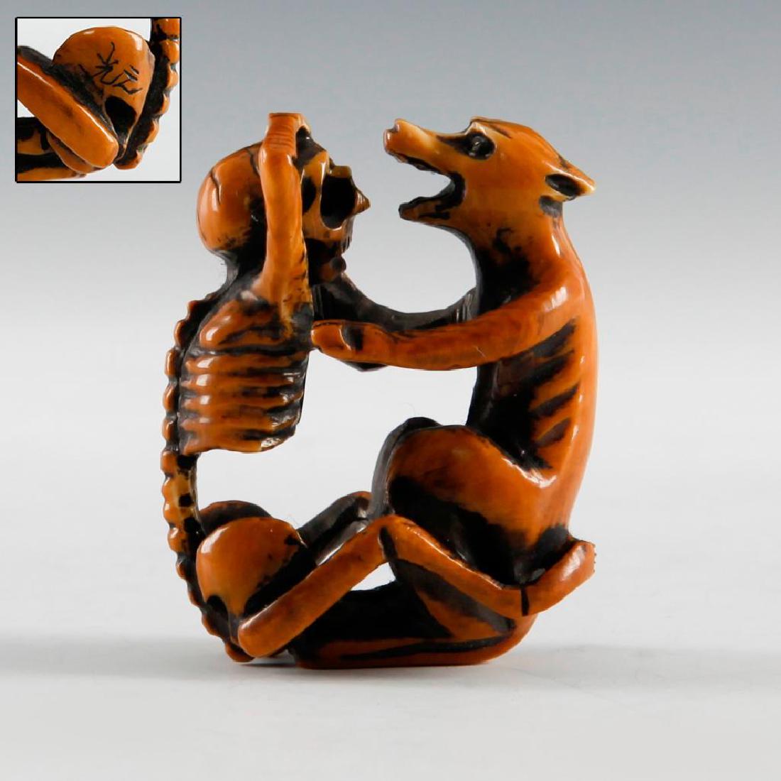 ANTIQUE JAPANESE CARVED BONE NETSUKE SKELETON & WOLF: Netsuke carving of a skeleton wrestling with wolf. Signed on the side. Dimensions: 2"H Country of Origin: Japan