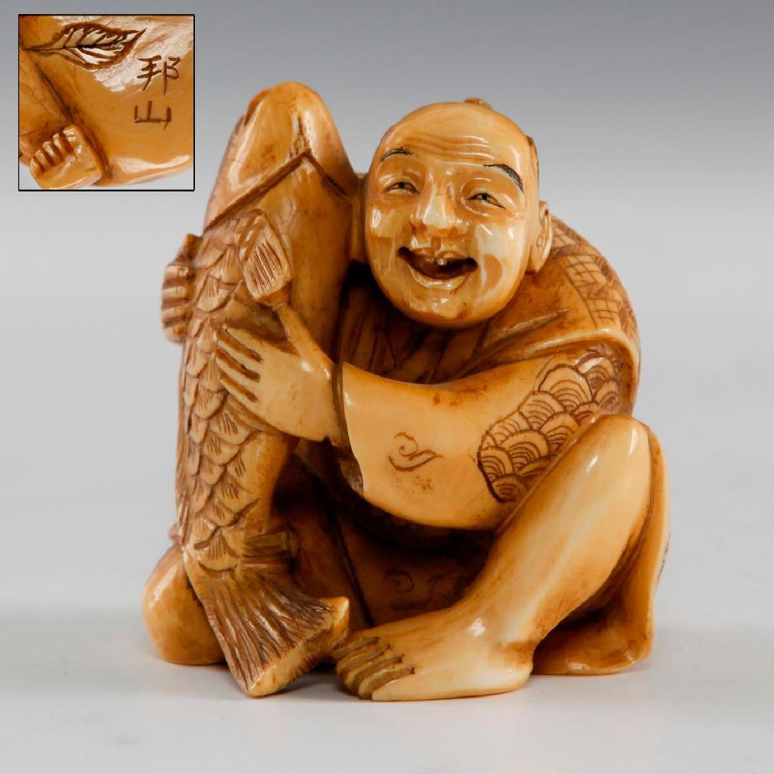 ANTIQUE JAPANESE CARVED BONE NETSUKE FIGURE MAN & FISH: Netsuke carving as a Man with a Tai Fish, a symbol of Good Luck. Signed on the bottom. Dimensions: 2"H Country of Origin: Japan