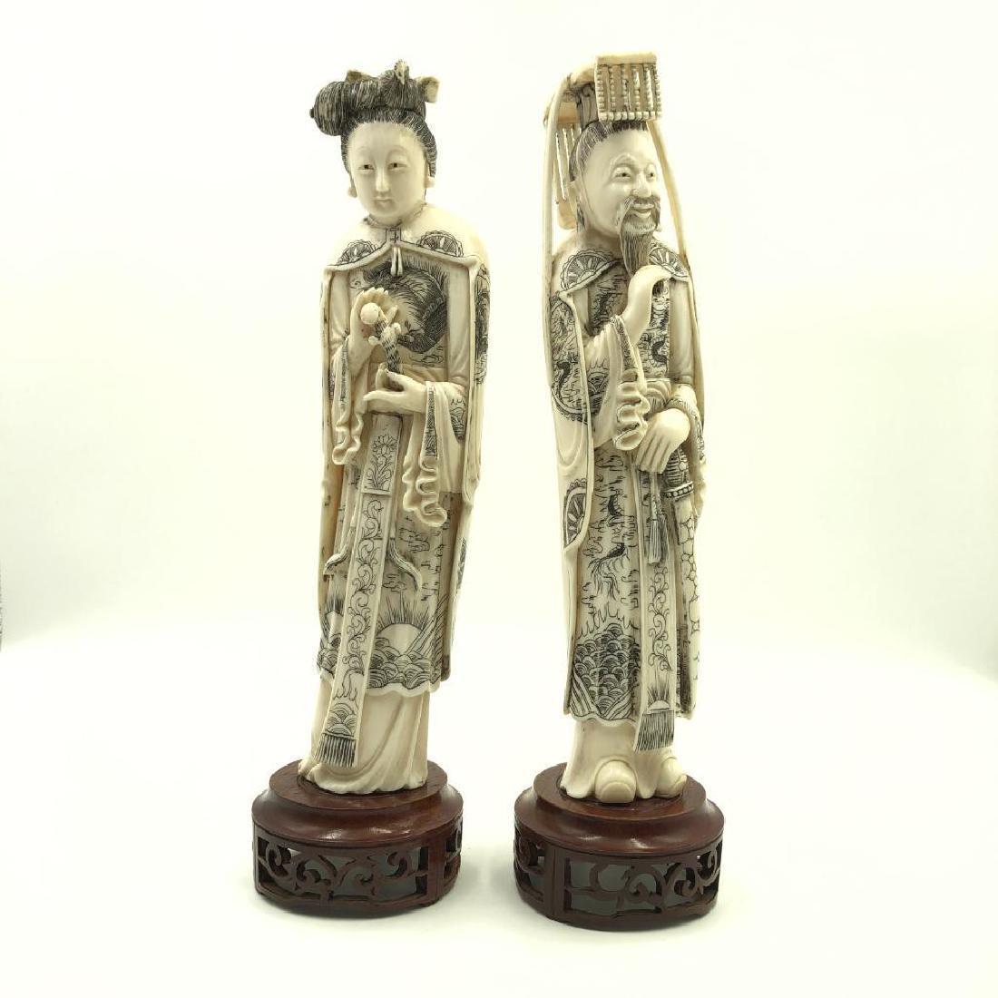 CARVED BONE CHINESE FIGURES MALE AND FEMALE SCRIMSHAW: Set of ceremonially dressed Chinese figures in ox bone on base. Base of carved wood, possibly added after original manufacture. Scrimshaw style decoration back and front. Dimensions: Tallest 11.5"H Co