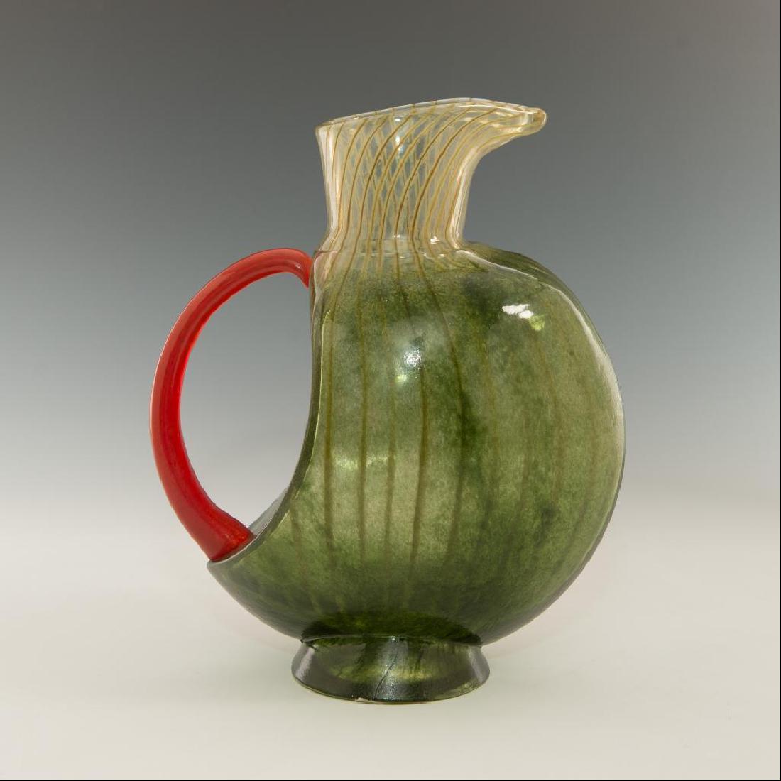 KJELL ENGMAN FOR KOSTA BODA ART GLASS PITCHER JAR: Handblown glass carafe in green and red from Corfu collection. Marked on the bottom. Model number 7080572. Dimensions: 10.5"H x about 8"W Issued: Circa mid 20th century Country of Origin: Sweden Artis