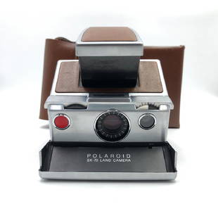 VINTAGE POLAROID LAND SX-70 INSTANT CAMERA WITH CASE: Iconic 1970's folding design, opens, closes easily, leather case. Excellent cosmetic condition with unfogged lenses and supple, pinhole-free bellows. Case is clean and red velvet lined. Dimensions: 8.