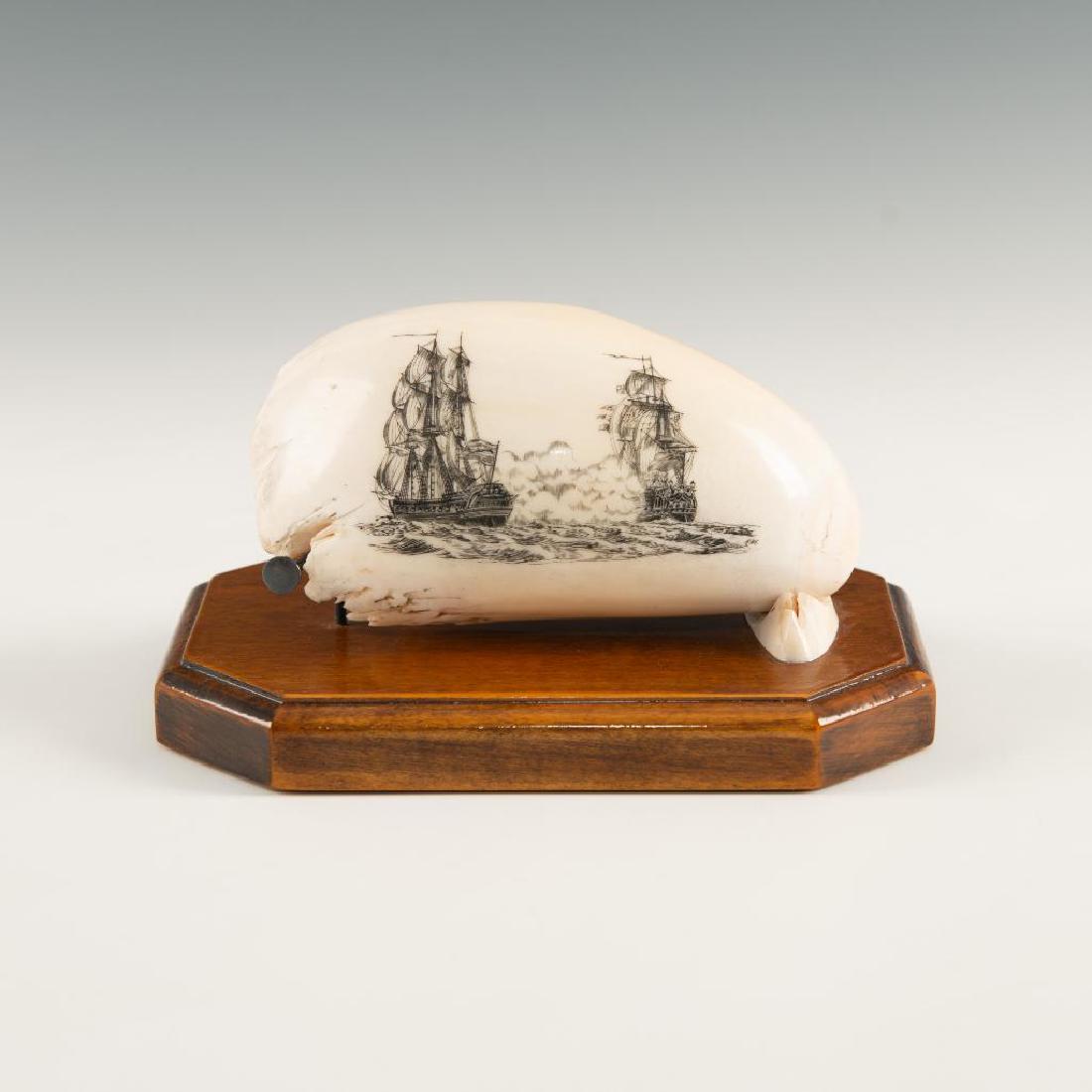 FOSSILIZED SPERM WHALE TOOTH SCRIMSHAW BY R. MONFILS: Battle scene between ships of the line, with wood and bone base. Richly illustrated battle scene from late 20th century American schrimshaw artist Robert Monfils (signed). Includes oak base which fetu