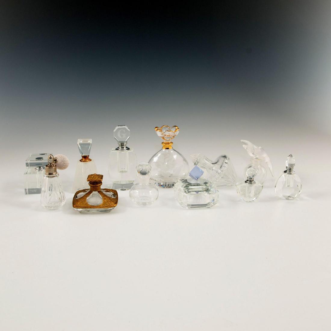 GROUP OF 12 CRYSTAL ART GLASS PERFUME BOTTLES LALIQUE: Grouping of 11 various perfume bottles and lidded cut crystal box Lot includes Lalique for Nina Ricci Two Doves stopper bottle, two Oleg Cassini, one Arte Italica, Neiman Marcus, Dartington and others