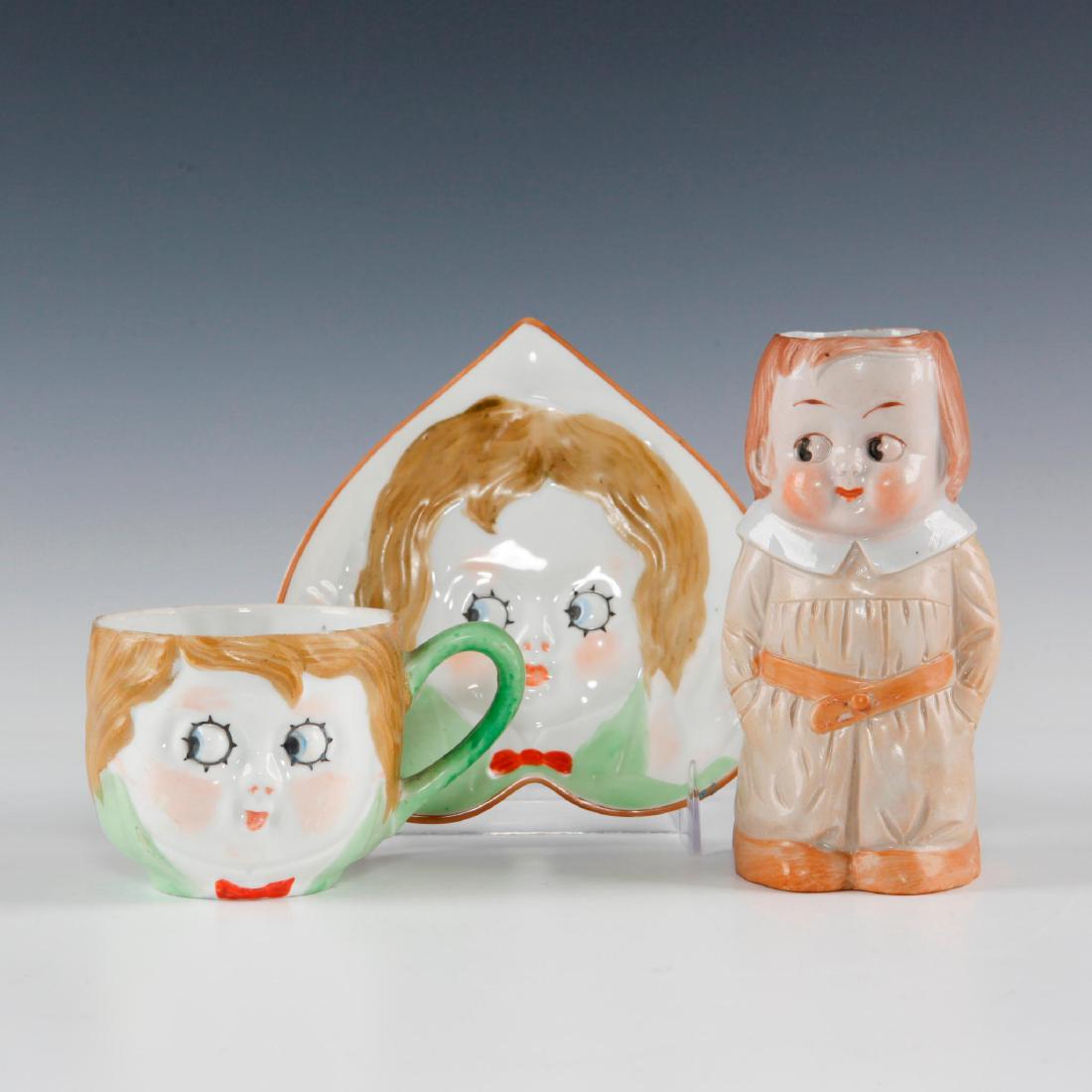 GROUP OF 3 KEWPIE DOLL CHILDREN, CANDY DISH, CUP, JUG: Kewpies made by Noritake predecessor, Nippon Toki; jug unknown. Kewpie pieces marked HAND PAINTED NIPPON, dating them from 1911-1921. Jug has several unknown but legible potter's marks to back bottom 