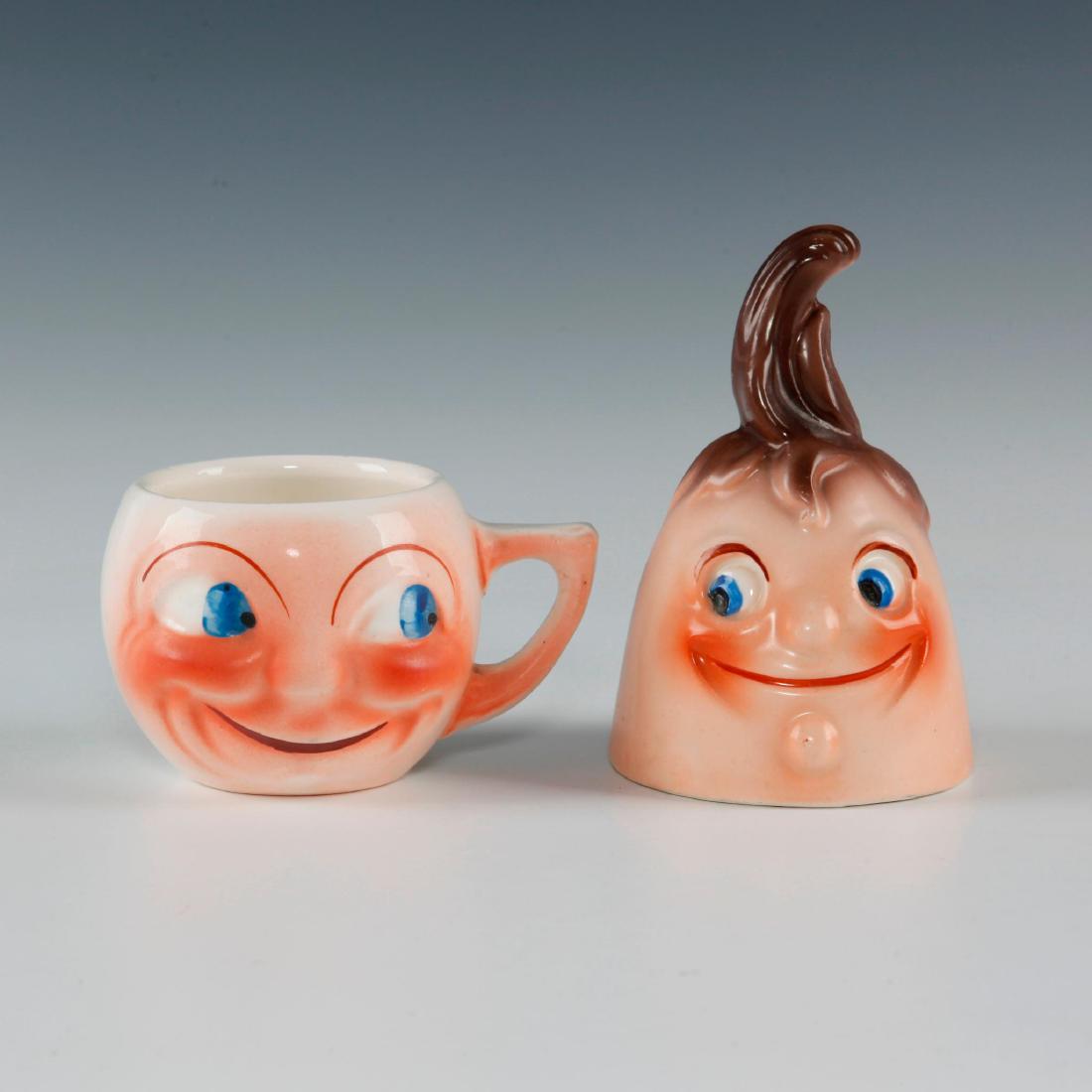 GROUP 2 CZECH PORCELAIN HAPPY FACE MAN SMALL MUG & BELL: Glazed. Smiling Man in the Moon motif, blue eyes. Cup Markings: PORCELANIT, J M, MADE IN CZECHOSLOVAKIA, ZAKONEM CHRANENO (Czech: "legally protected design"). Bell: MADE IN CZECHOSLOVAKIA. Issued: c. 