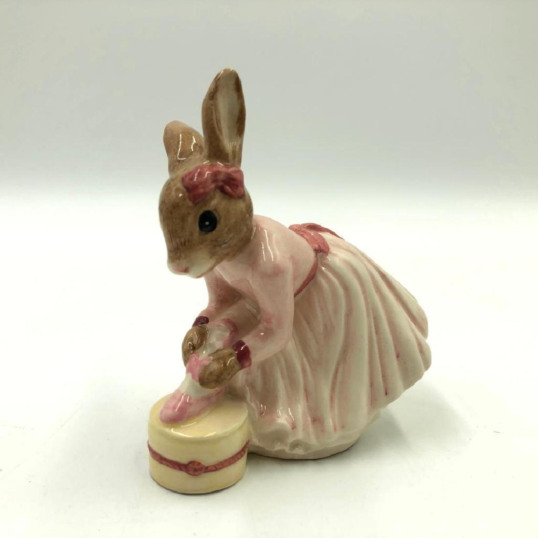 ROYAL DOULTON BALLERINA BUNNYKINS DB176: Bunny putting on her ballet shoes. Hand painted pink dress and yellow footstool. Artist: Graham Tongue Issued: 1998-2001 Dimensions: 3.5"H Manufacturer: Royal Doulton Country of Origin: England