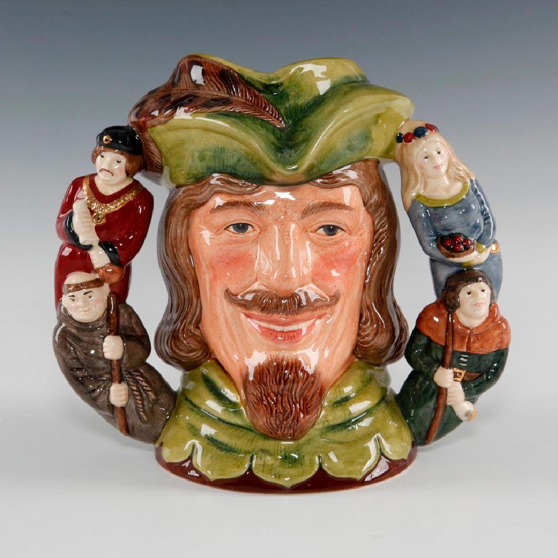 ROYAL DOULTON ROBIN HOOD TWO-HANDLE LARGE JUG D6998: From the Two-Handled Character Jug Series. Smiling Robin Hood with green hat and tunic collar with brown. Handle depicts figures of Maid Marion, Friar Tuck, Little John and The Sheriff of Nottingham. 