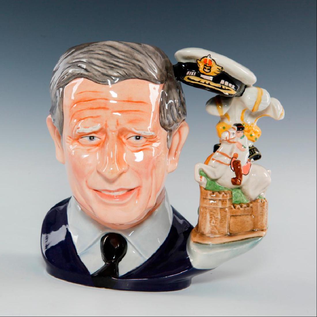 ROYAL DOULTON PRINCE CHARLES LARGE JUG D7283: 2008 Character Jug of the Year. Handle includes a hat signifying his role as Admiral in the Royal Navy , Prince of Wales feathers, a horse and rider, and Caernarvon Castle where the Prince was vested.