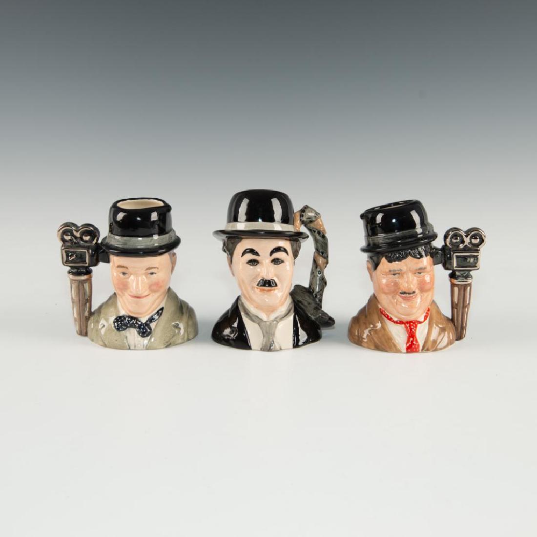 SET OF 3 ROYAL DOULTON CELEBRITES SMALL JUG: Jugs depict most popular actors in motion picture history. Includes Charlie Chaplin D7145 edition number 680, Oliver Hardy D7009 edition number 1014 and Stan Laurel D7008 edition number 1014. Tallest:
