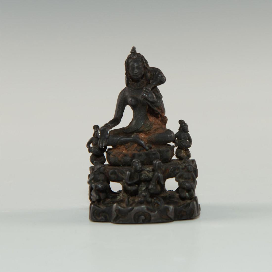 CHINESE / SOUTHEAST ASIAN BRONZE GODDESS: Exquisitely sculpted and cast with rich dark bronze patina all over, Immortal divinity on lotus with one hand palm raised up, other hand gripping lotus flower. Surrounded by heavenly six attendants, s