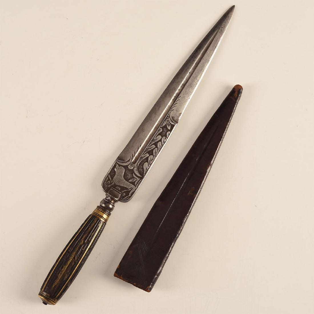 ENGRAVED MEDITERRANEAN DAGGER WITH INLAID HORN HANDLE: Brass inlay in handle, deep engraved animal figure on both sides of blade. Early 19th c. Long, Spanish-style false edge opposite main edge, spear point blade shape. Deep filleting and brass inlay in t