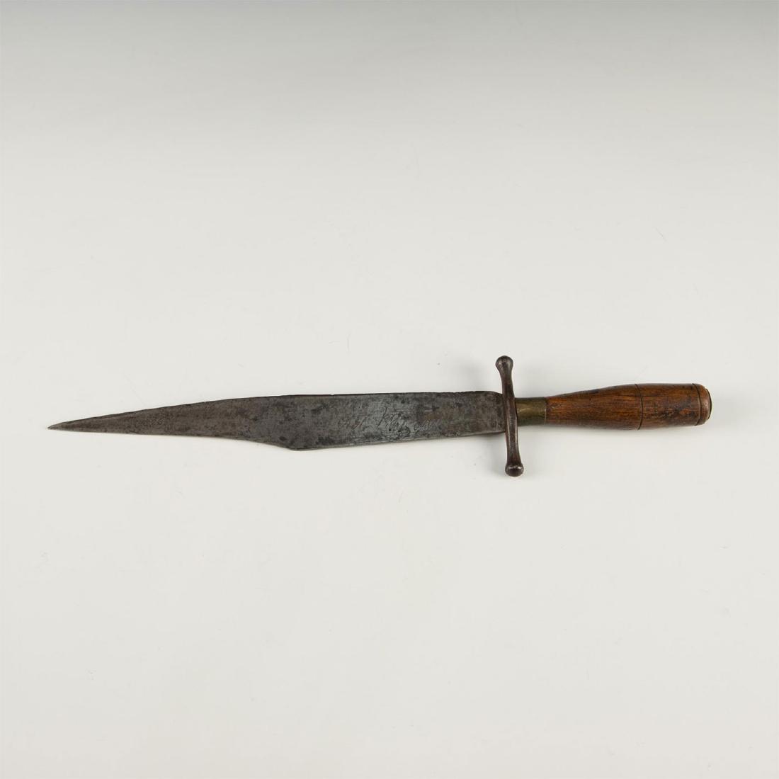 ANTIQUE SPANISH BOWIE KNIFE, ENGRAVED 1816: Cross guard, wood handle, brass ferule. Script and numbers "1816" written on side. A unique piece, this design, superficially similar to a bowie knife, was a popular style of hunting and fighting knif