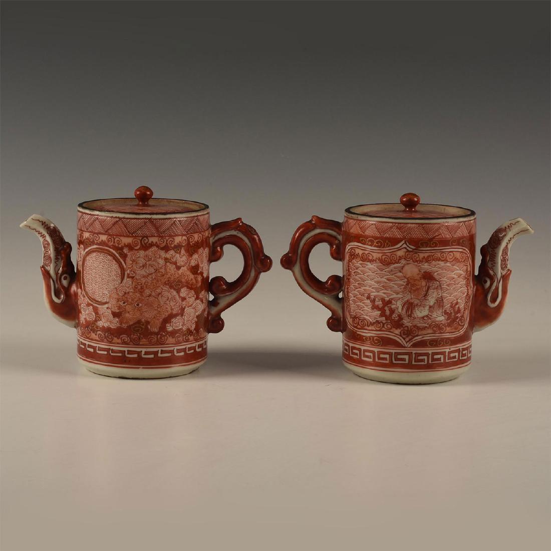 TWO JAPANESE KUTANI PORCELAIN TEA POTS: Decorations of stylized cats and scholars. A group of two Japanese Kutani porcelain tea kettles with lids. One with two exemplary stylized Asian cats with florals. Marked to base, tag TOKUGAWA [18TH C