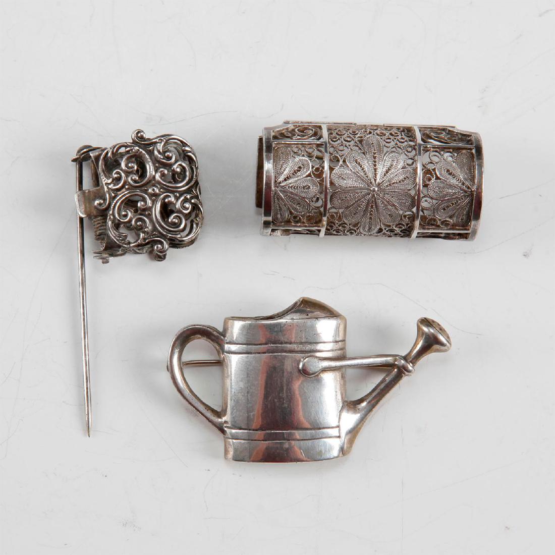 SET OF 3 VICTORIAN ENGLISH SILVER POSEY PINS: Two filigree boutonniere lapel flower holders and one Watering Can motif brooch all with back pin clips. 1) Hallmarked sterling silver barrel floral mesh box form posy holder with back pin. 2) Silver