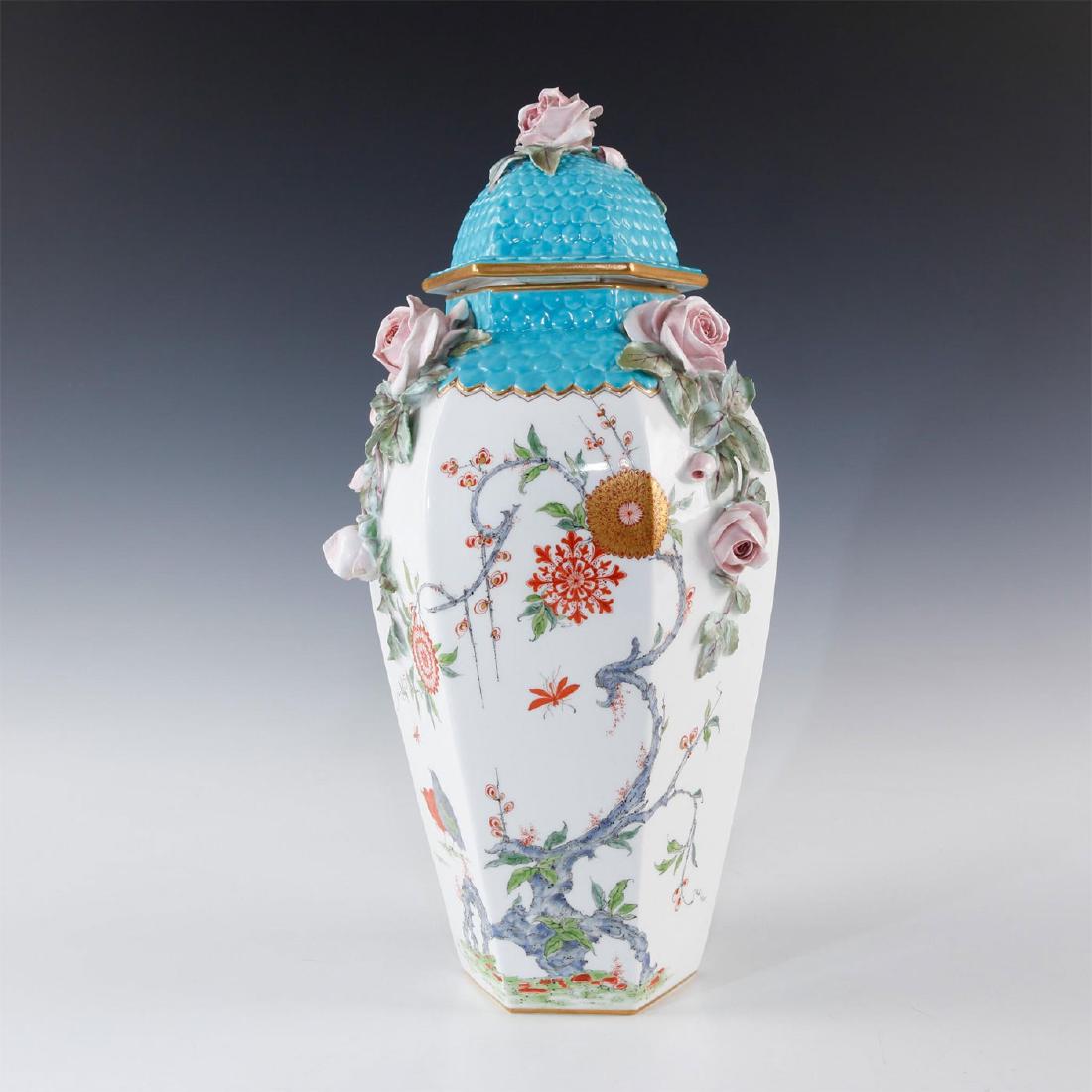 ROYAL WORCESTER RAISED DECORATION FLORAL VASE WITH LID: Profuse raised floral decorations of roses. Gilt and turquoise. Glazed white porcelain, hexagonal six-sided shape with turquoise to top, profuse floral decorations and raised relief pink roses and rai