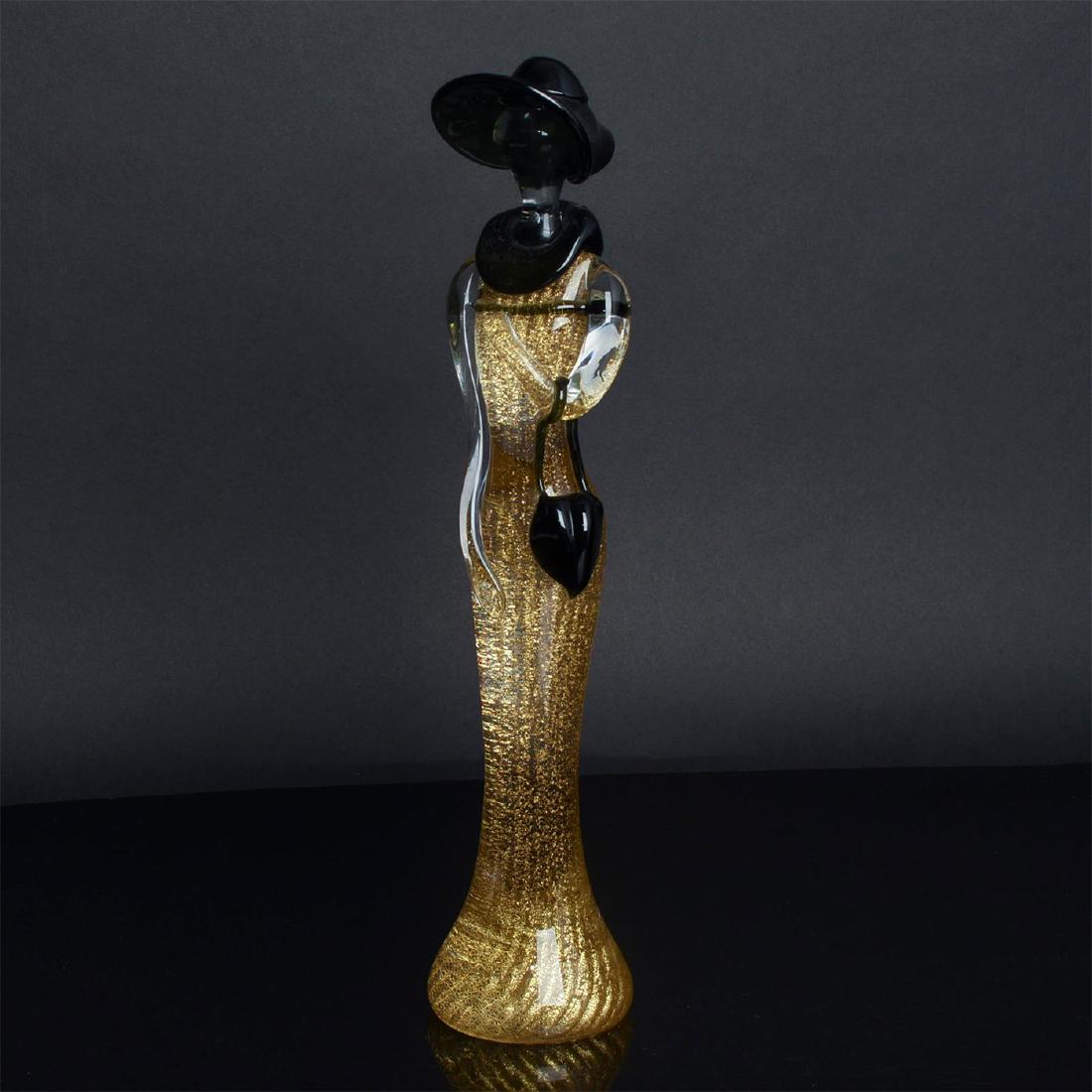 MURANO ART DECO STYLE GLASS SCULPTURE SIGNED BY MARIO: Opaque glass, artist signed. Frosted opaline opaque colored glass with interior decorations of gilt. Modeled as a stylized woman in 1920s style dress with black glass color, hat, and handbag. Original