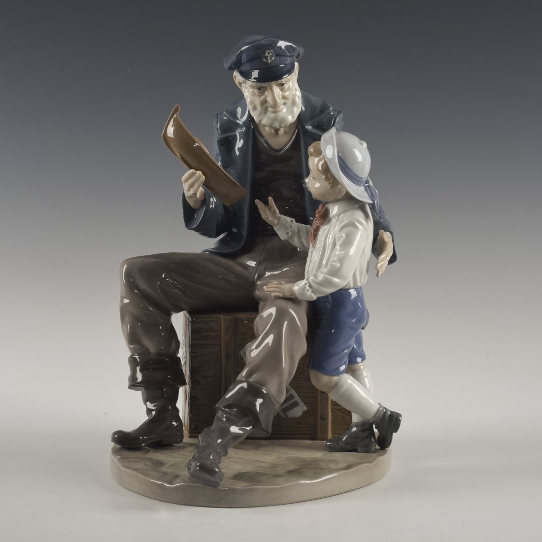 LLADRO FIGURINE A TALL YARN: Captain showing boy toy boat - Lladro number 01005207. Viejo Marinero y su Nieto Artist: Salvador Furio Issued: 1984 Dimensions: H-11.00" Manufacturer: Lladro Country of Origin: Spain