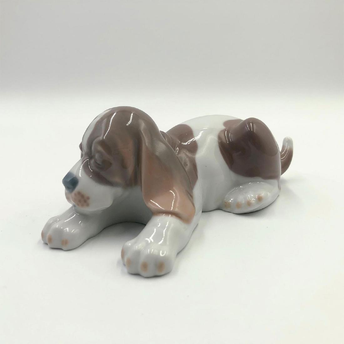 LLADRO FIGURINE BEAGLE PUPPY LYING: A brown and white dog sleeping all time - Lladro number 1001072. PERRO DORMILON Artist: Julio Fernandez Issued: 1969 Dimensions: 2.25"H Manufacturer: Lladro Country of Origin: Spain