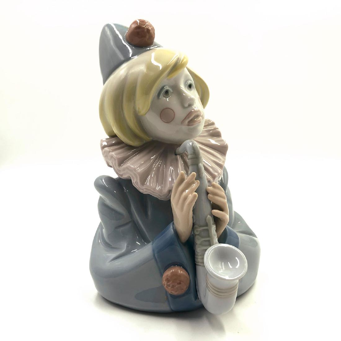 LLADRO FIGURINE SAD NOTE: Clown playing saxophone - Lladro number 01005586. BUSTO PAYASITO SAXOFON Artist: Francisco Catala Issued: 1989 Dimensions: 9.01"H Manufacturer: Lladro Country of Origin: Spain