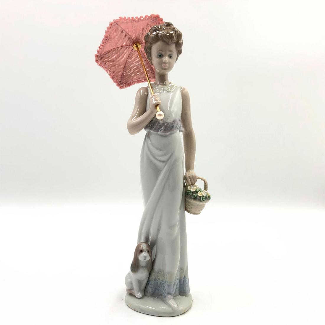 LLADRO FIGURINE GARDEN CLASSIC: Lady with umbrella and flowers with dog - Lladro number 01007617. PASEANDO POR EL JARDIN (with box). Artist: Juan Huerta Issued: 1991 Dimensions: 9"H Manufacturer: Lladro Country of Origin: Spain