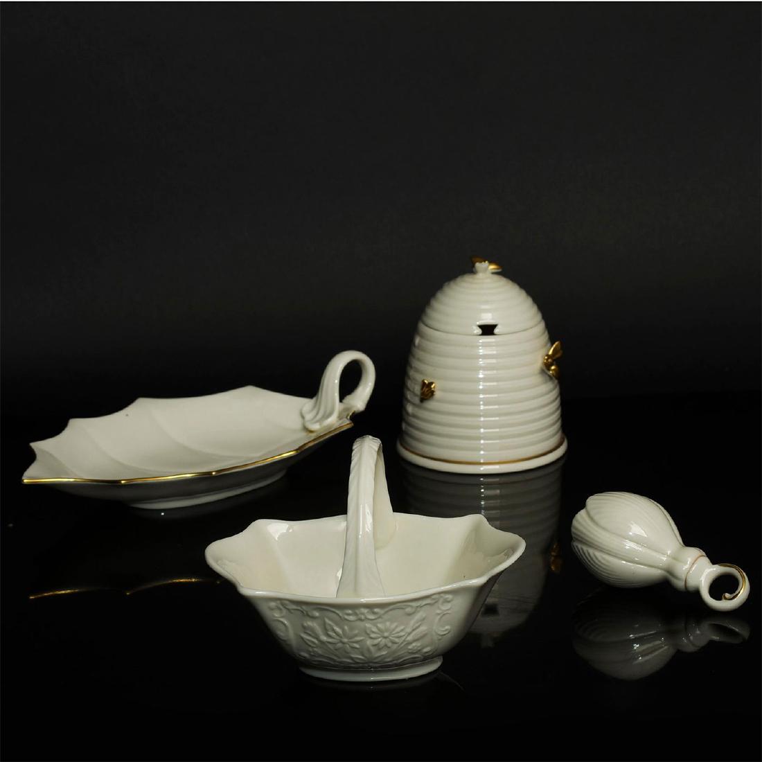 LOT OF 4 LENOX GILT CREAM CHINA TABLE PIECES: Toppered beehive sugar bowl, basket and leaf dish, decorative flower bud bell. Dimensions: 10"L X 5.5"D leaf, 6"D basket, 3.75"H bell, 5"H beehive Manufacturer: Lenox Country of Origin: United States