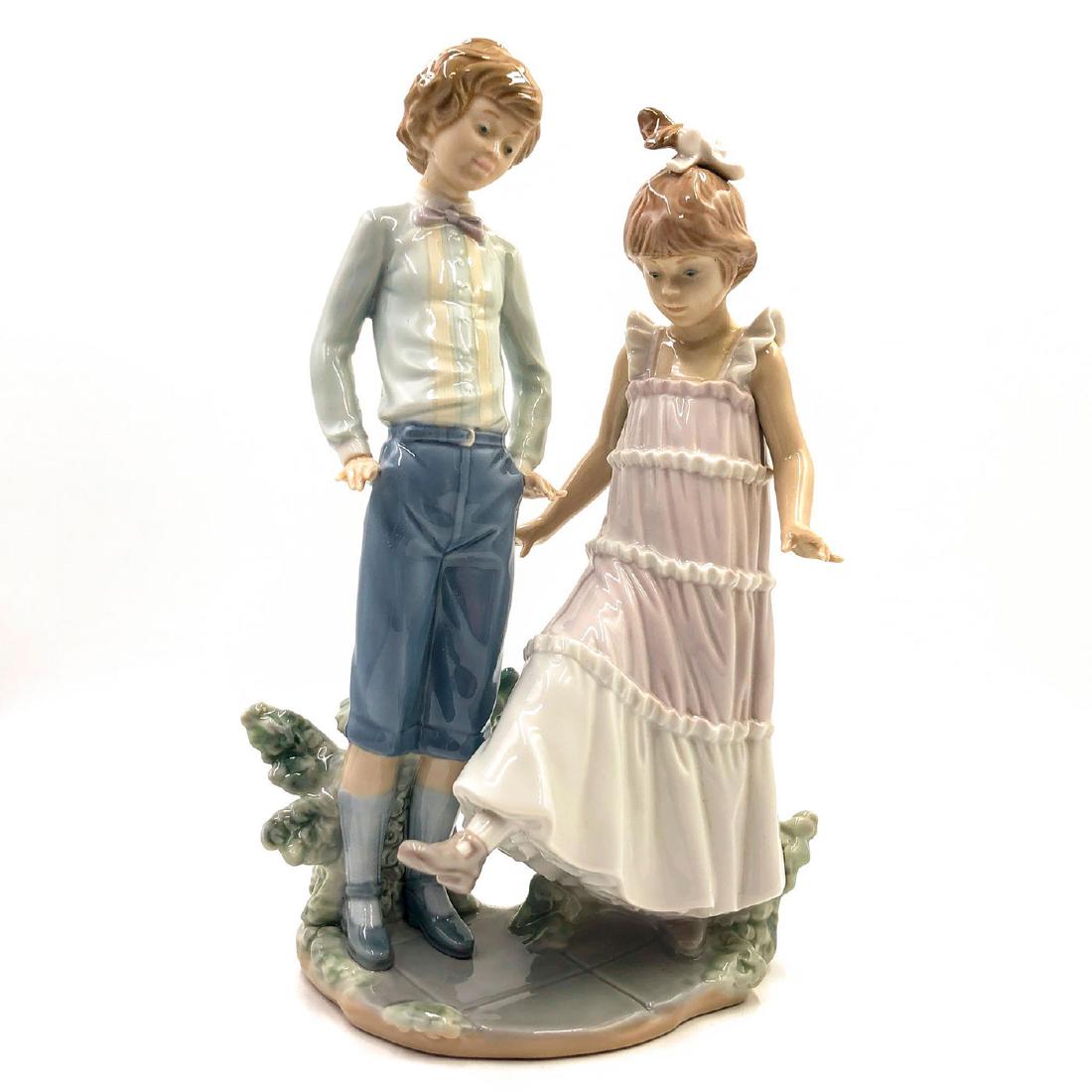 LLADRO FIGURINE ONE,TWO,THREE: Girl teaches boy to dance - Lladro number 01005426. Ensanando Los Zapatos. Artist: Jose Roig Issued: 1987 Dimensions: 10.75"H Manufacturer: Lladro Country of Origin: Spain