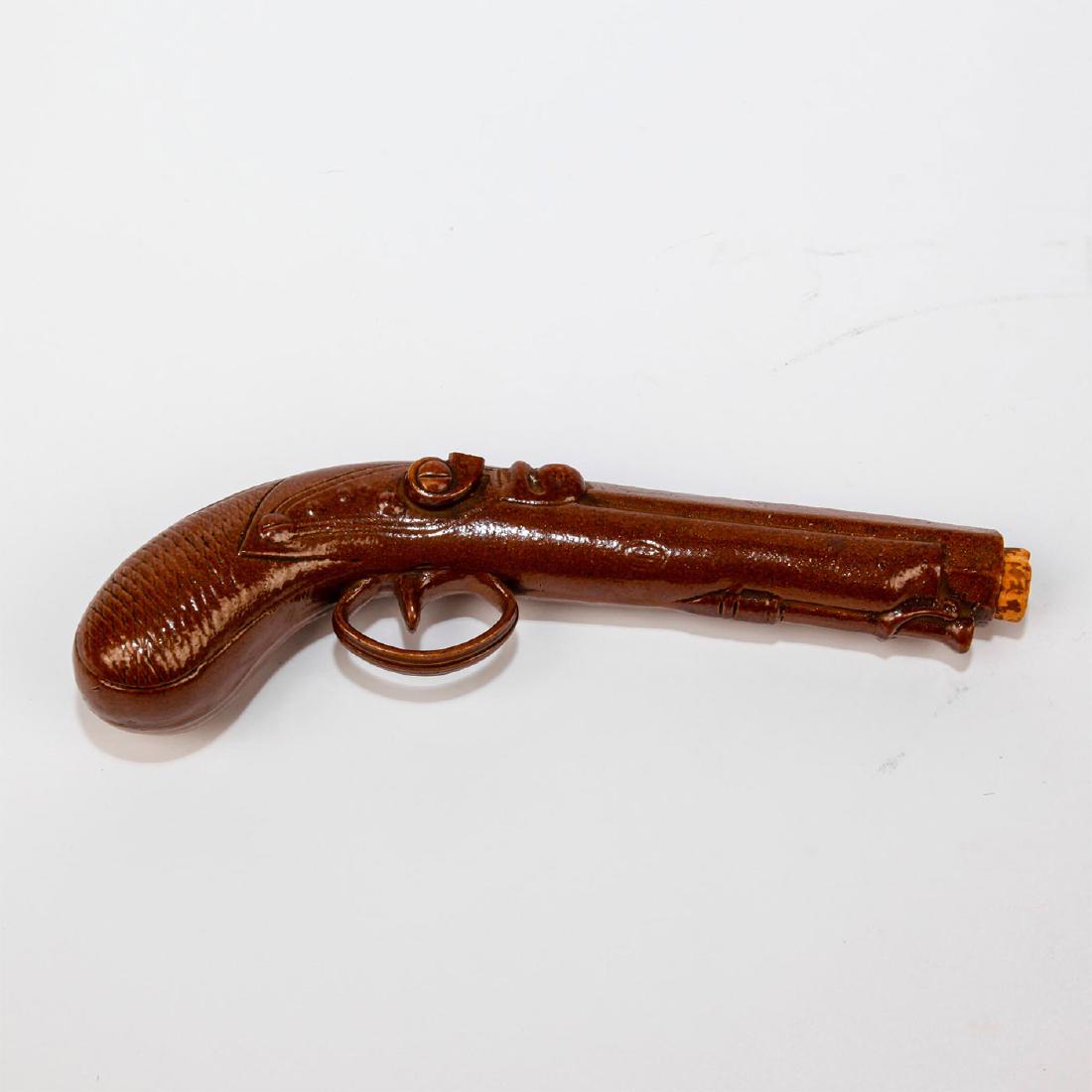 STONEWARE GUN WHISKEY BOTTLE: Rare early Lambeth stoneware bottle in the shape of a pistol. Issued: 1890s Dimensions: 10"L Country of Origin: England