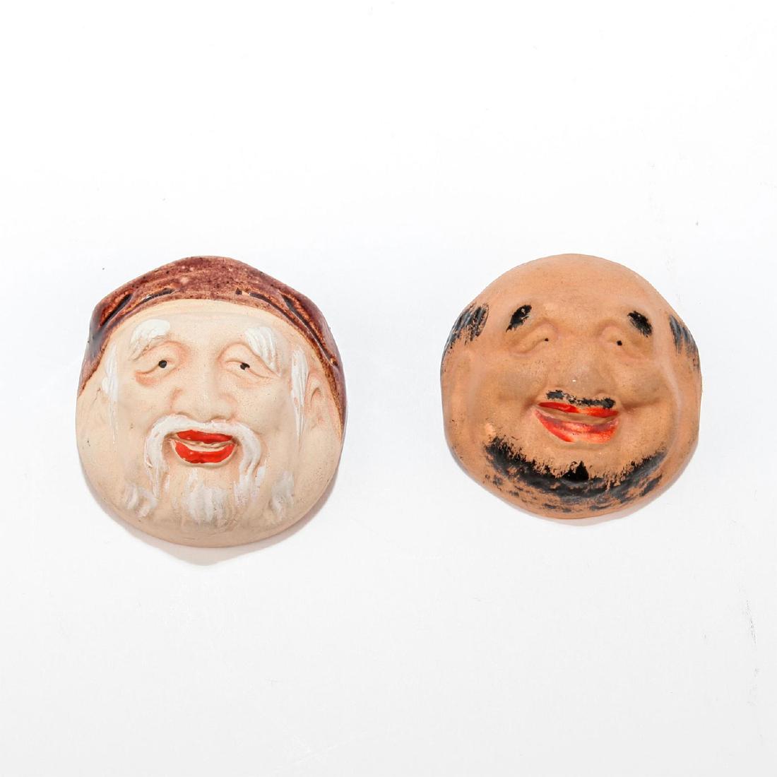 UNIQUE PAIR OF DOUBLE SIDED CERAMIC OPEN SALTS: Two freestanding open salts that, inverted, reveal molded faces. Decorative pieces, glazed and matte, unmarked. Dimensions: 1.75"D