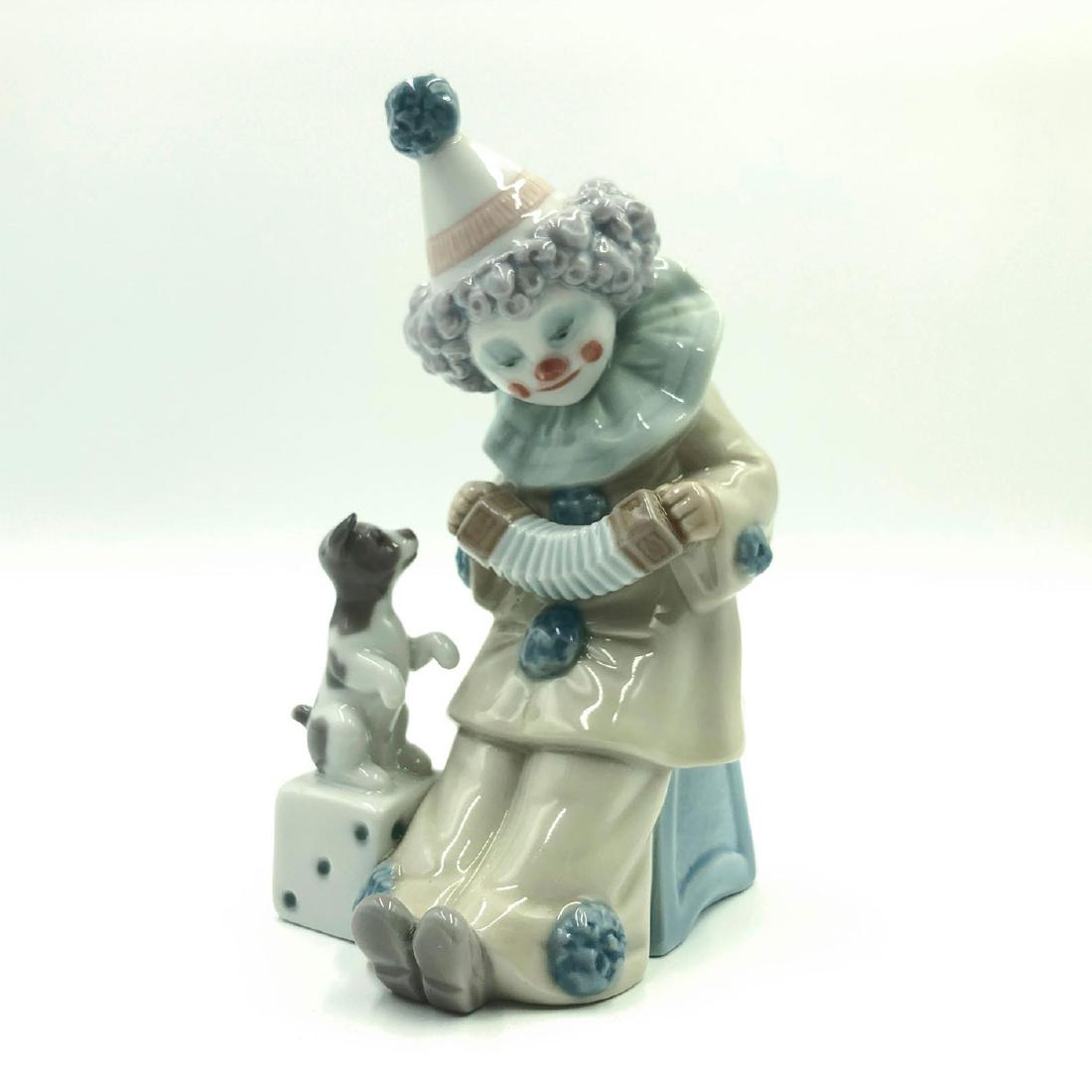 LLADRO FIGURINE PIERROT WITH CONCERTINA: Clown playing a concertina with a dog - Lladro number 01005279. NINO PIERROT CON PERRITO Y CONCERTINA Artist: Jose Puche Issued: 1985 Dimensions: 6"H Manufacturer: Lladro Country of Origin: Spain