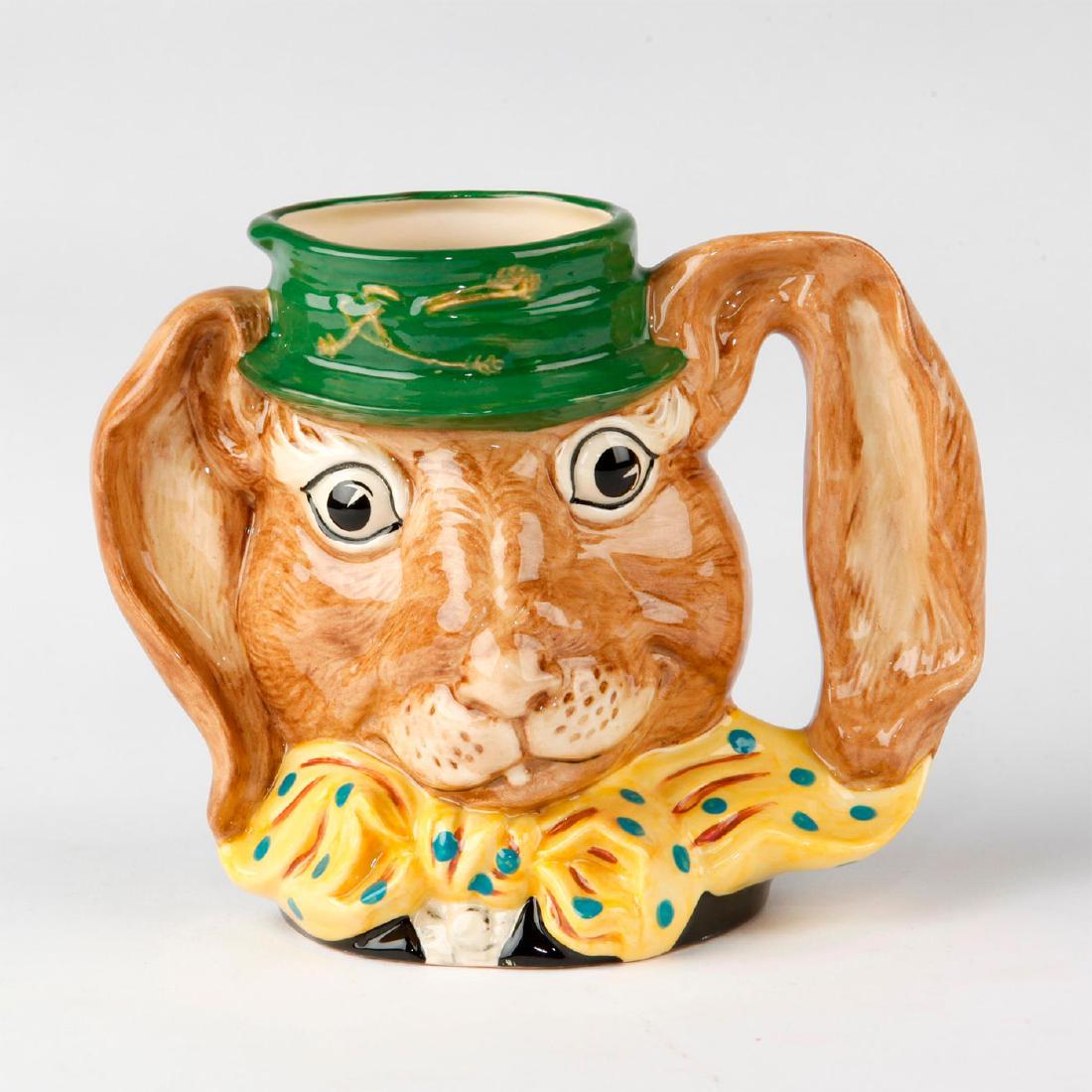 ROYAL DOULTON LARGE CHARACTER JUG, THE MARCH HARE: Large character jug designed for the Alice in Wonderland series. Jug D6776 shows March Hare in a green hat and a yellow bow tie designed with blue polka dots.One of the Hare's ears forms the handle. A