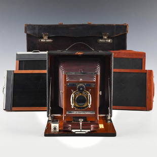 ANTIQUE FOLDING PLATE CAMERA WITH CASE, PLATE HOLDERS: Wollensak Mahogany camera with leather case. Case contains four plate holders. The leather has a reddish brown color, shows signs of use or age related wear. Camera is in good condition , also folds